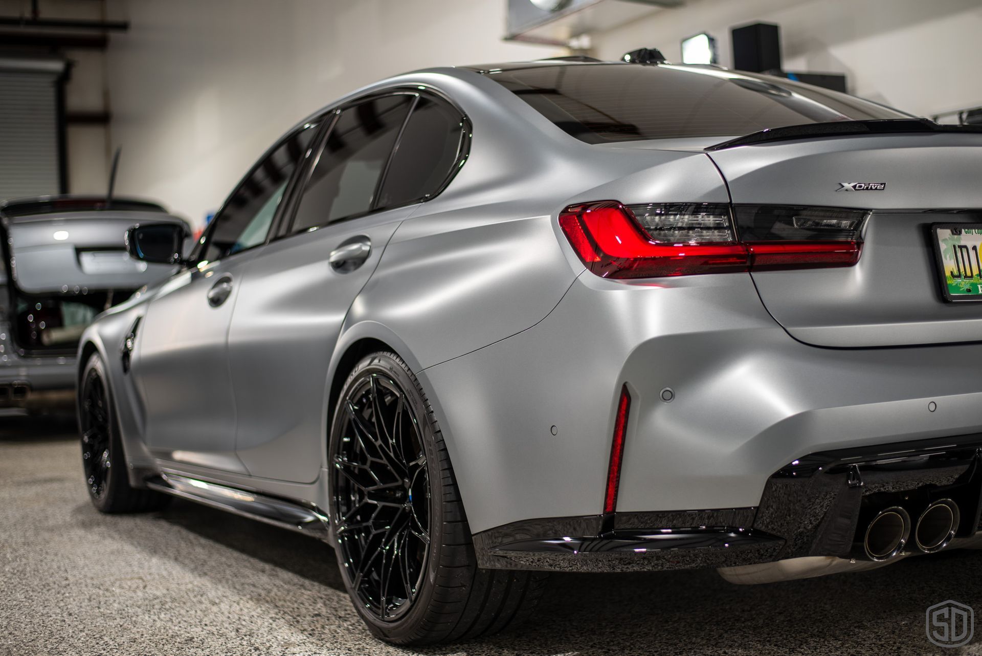 A silver bmw m3 is parked in a garage.