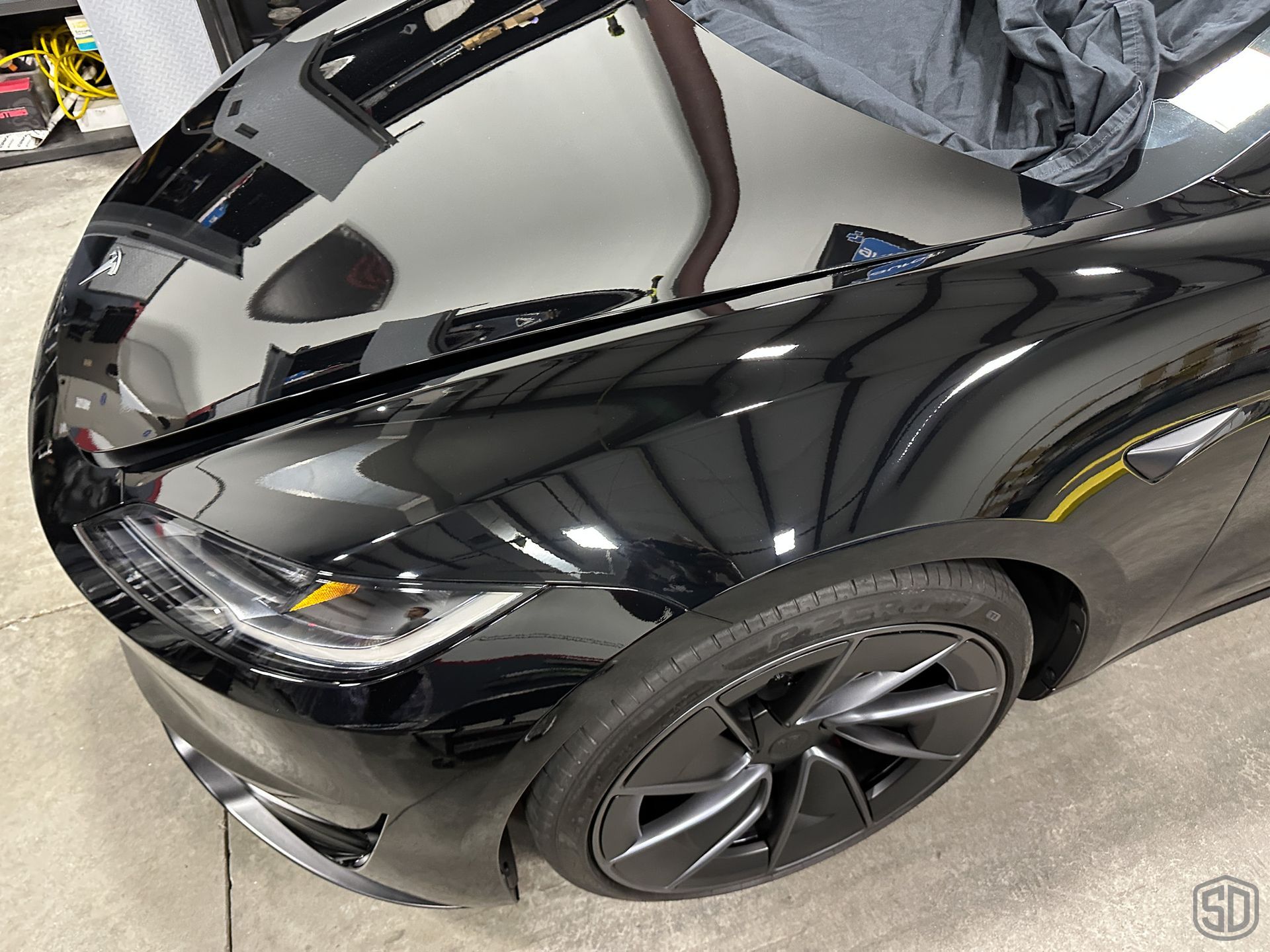 A closeup of a glossy black tesla with no streaks, swirls, or scratches