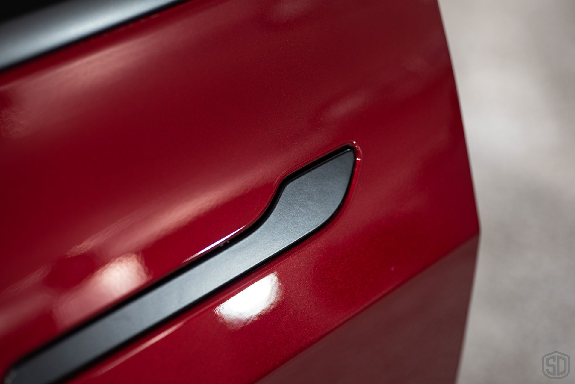 closeup of side door handle on red tesla