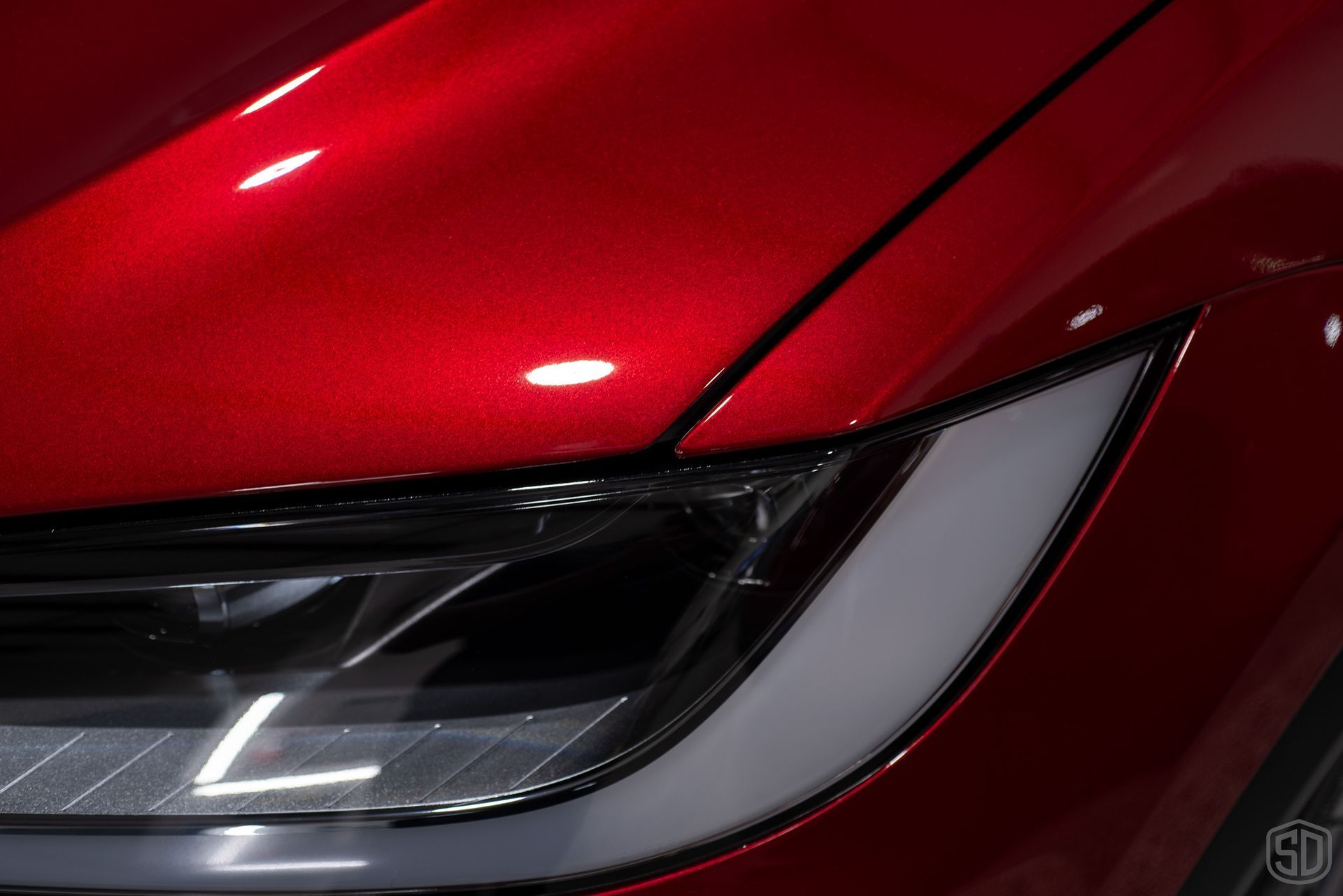 closeup of front headlights of red tesla