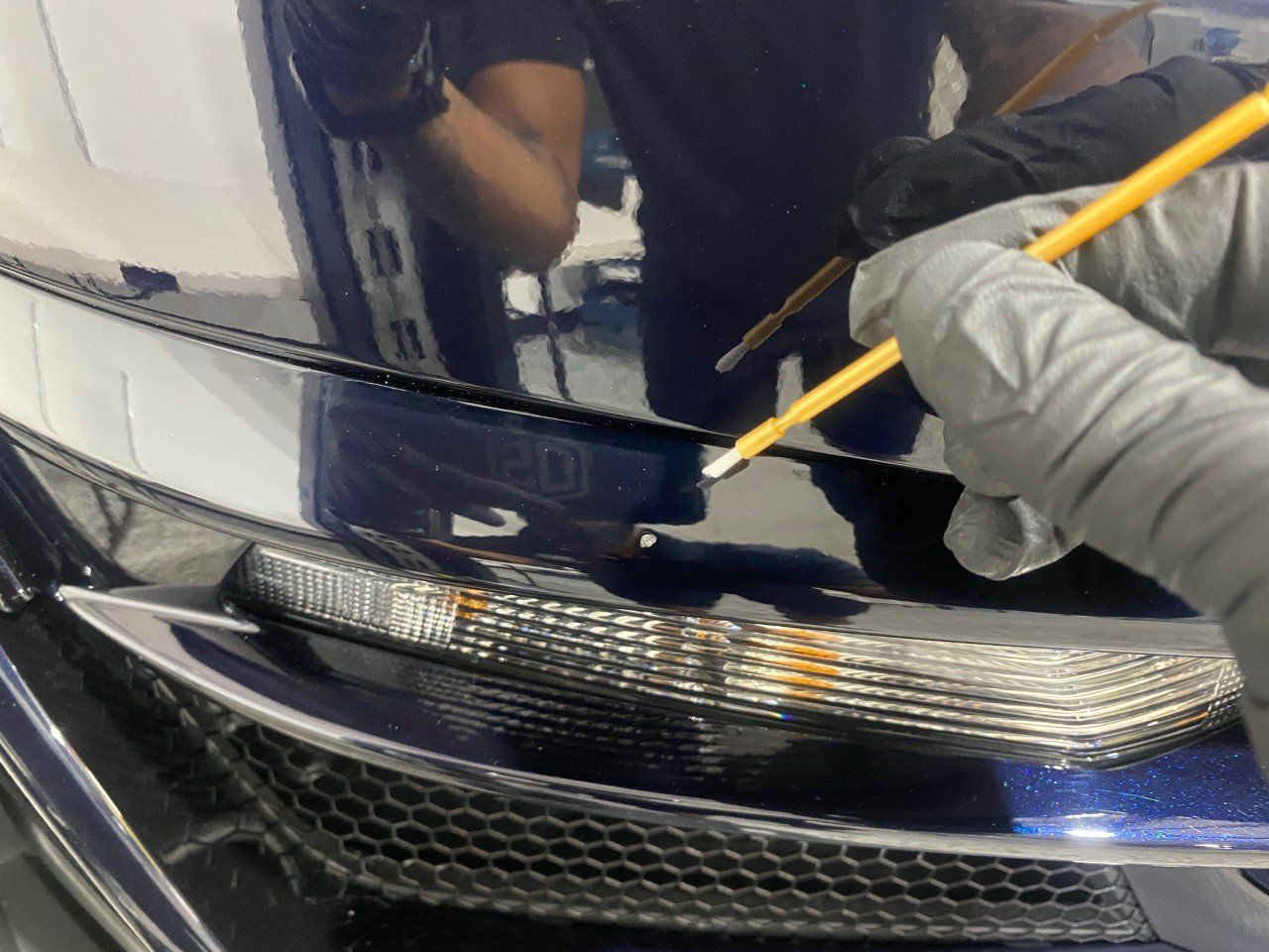 A person is painting a car with a pencil
