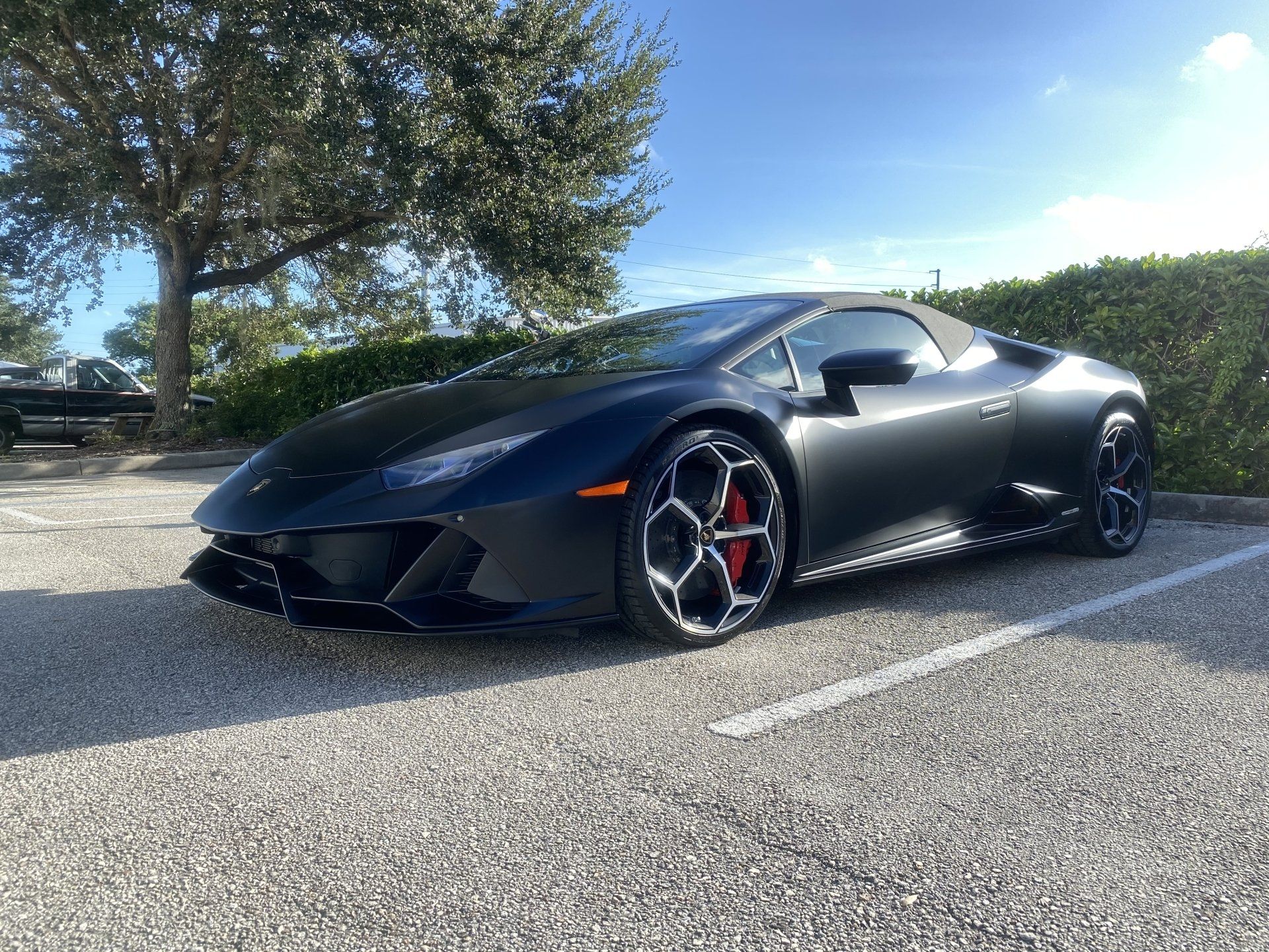 A black lamborghini huracan is parked in a parking lot.