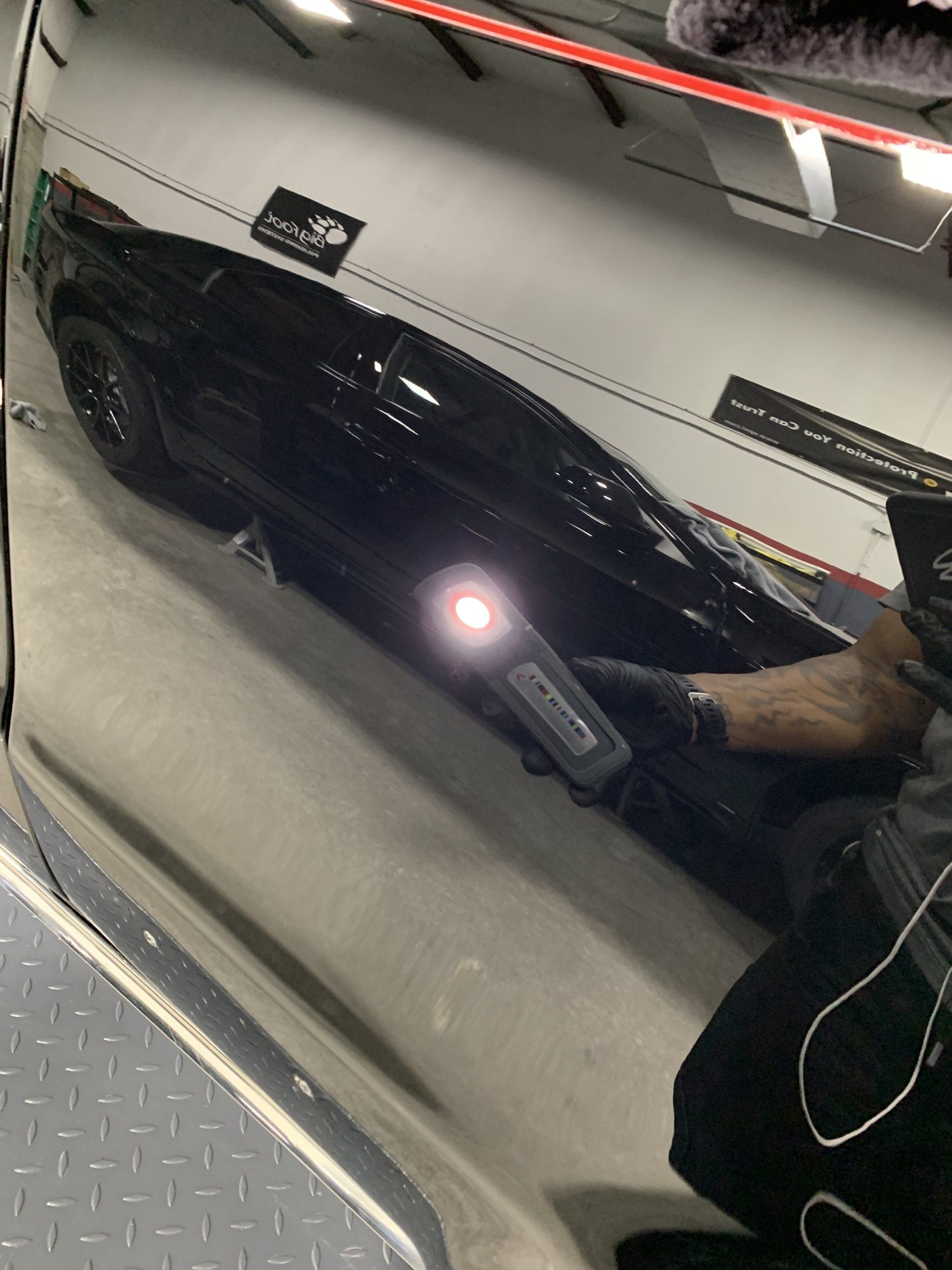 A black car is parked in a parking garage