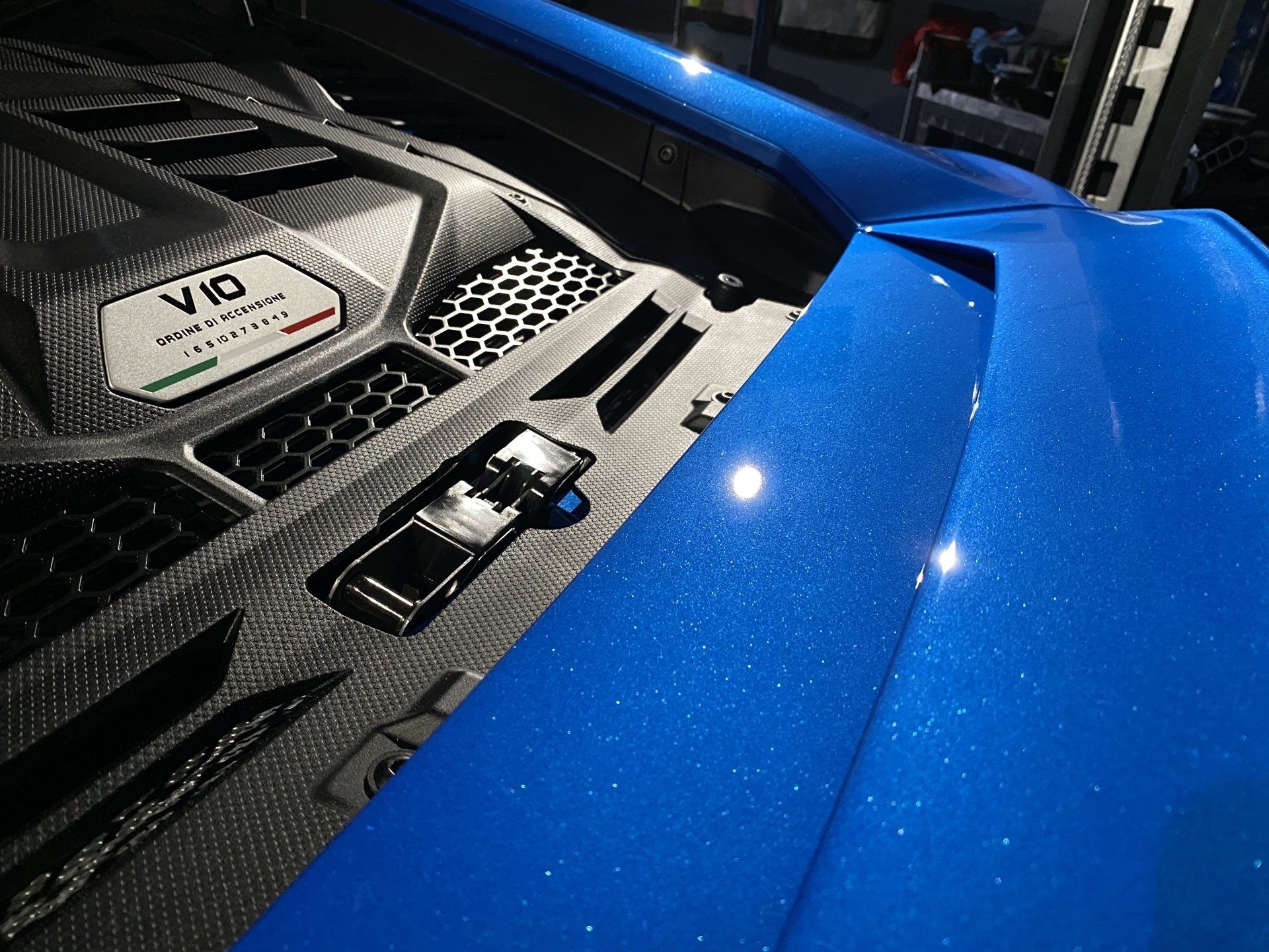 A close up of the hood of a blue sports car.