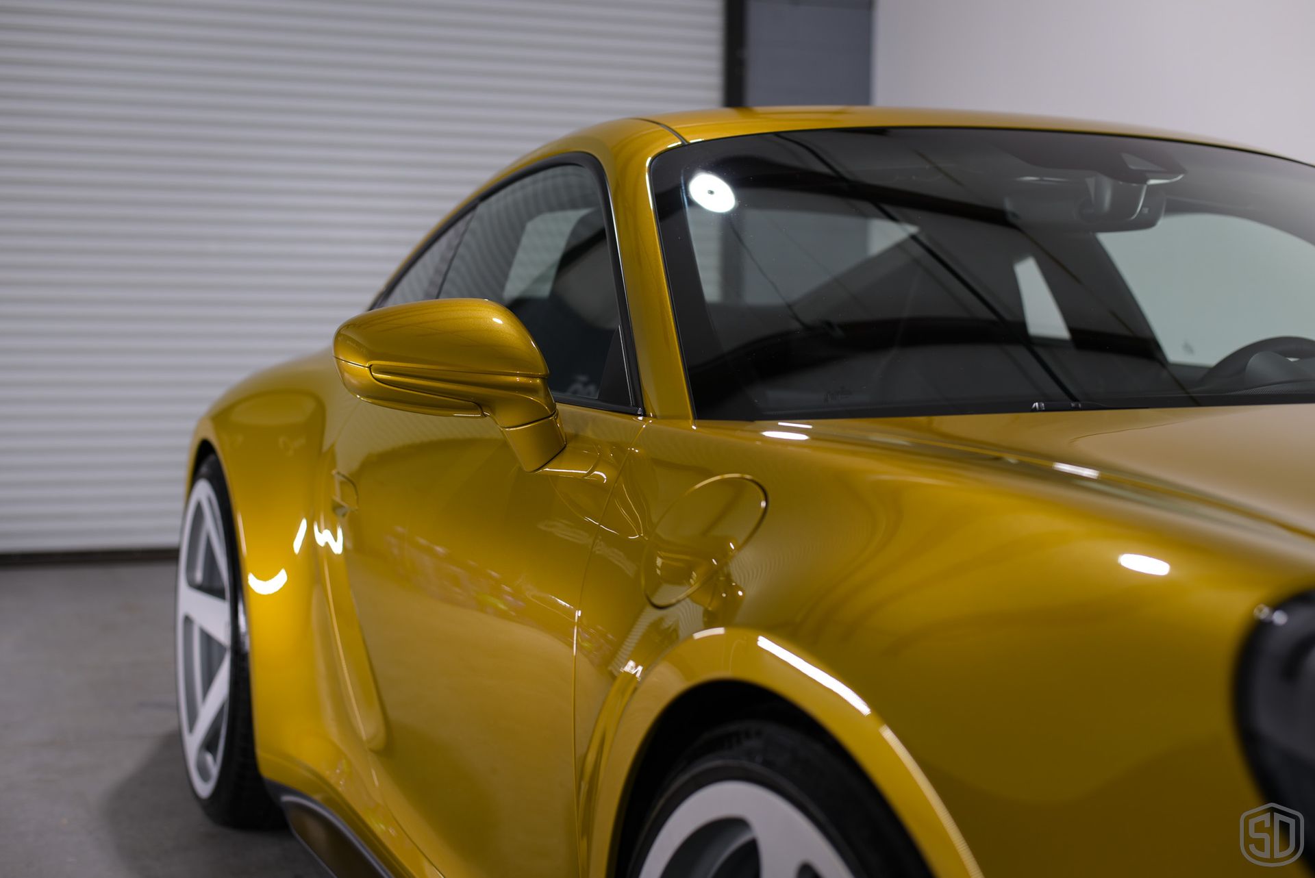 A close up of a yellow sports car parked in a garage.
