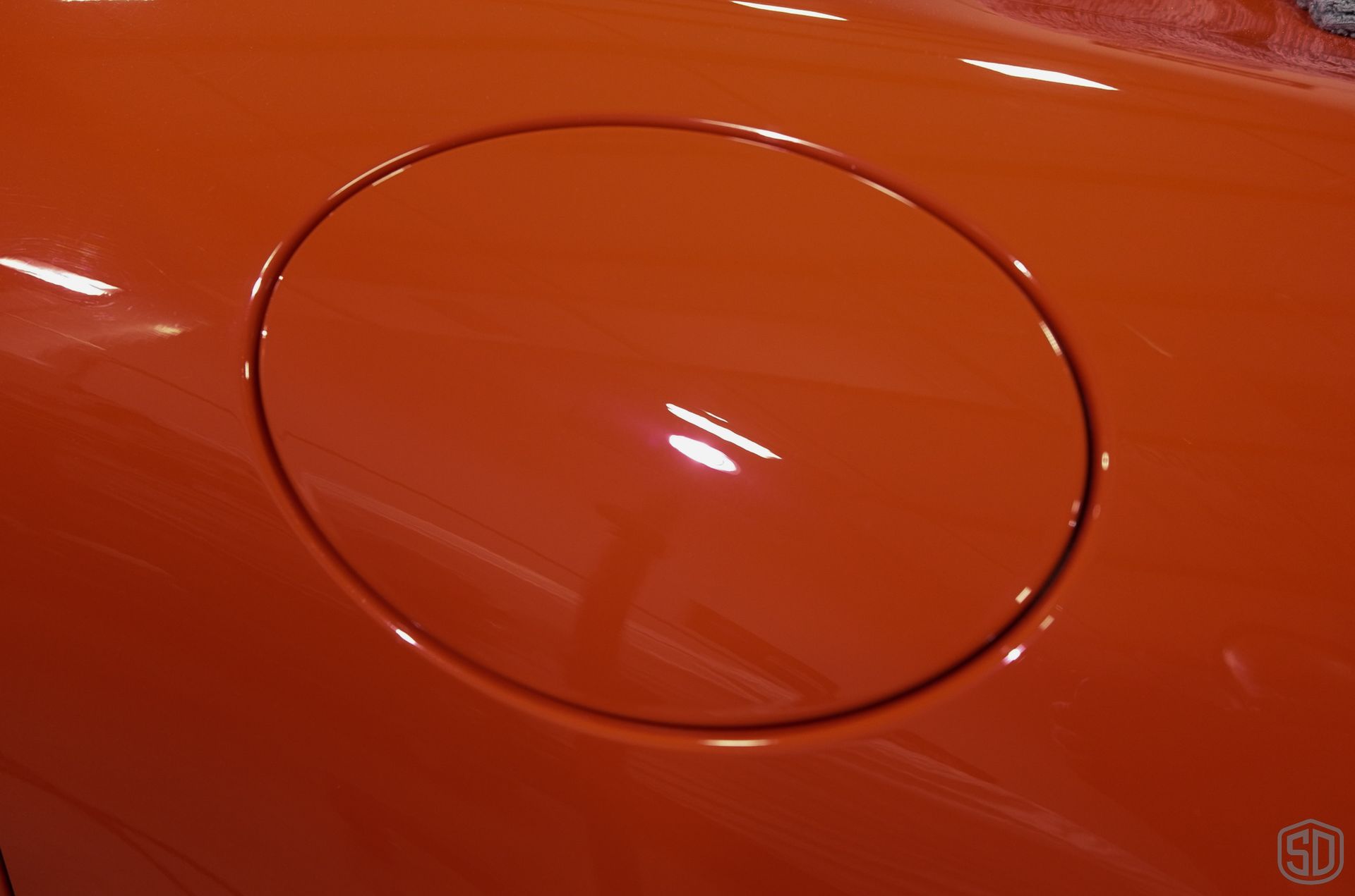 A close up of an orange car 's gas cap