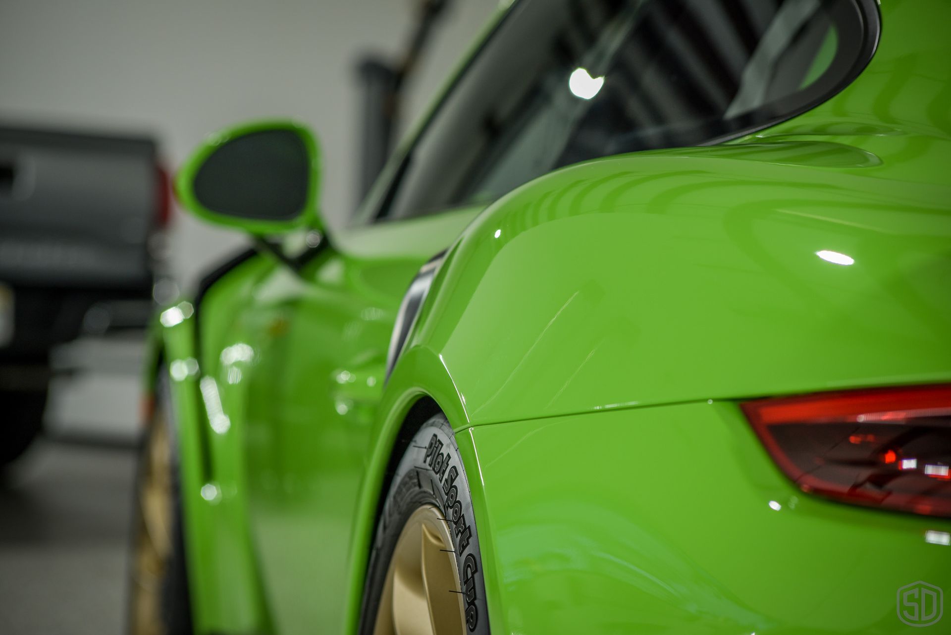 A close up of a green sports car parked in a garage.