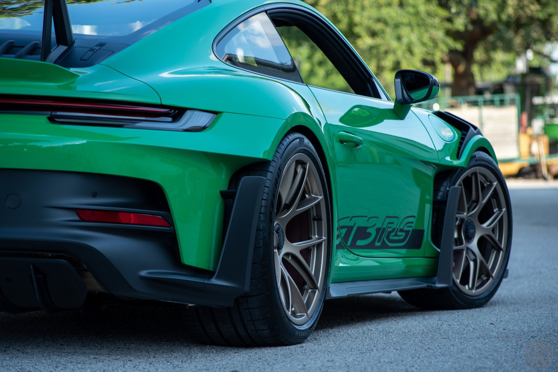A freshly detailed Python Green Porsche 911 GT3 RS is parked on a lot.