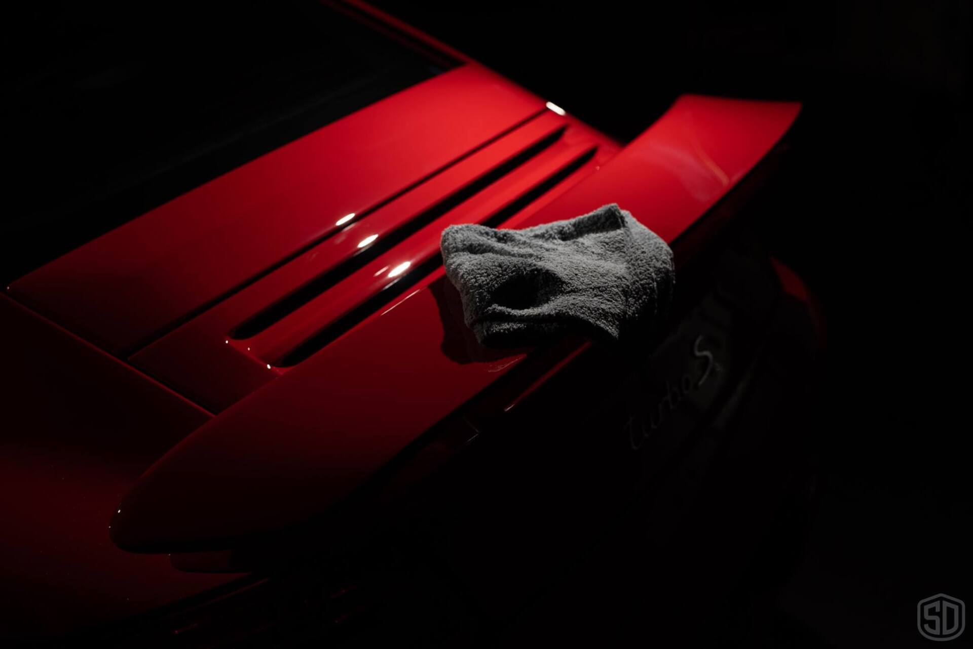 A red car with a towel on the hood