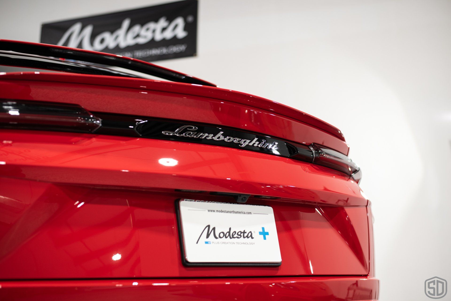 The back of a red lamborghini with a license plate that says modesta