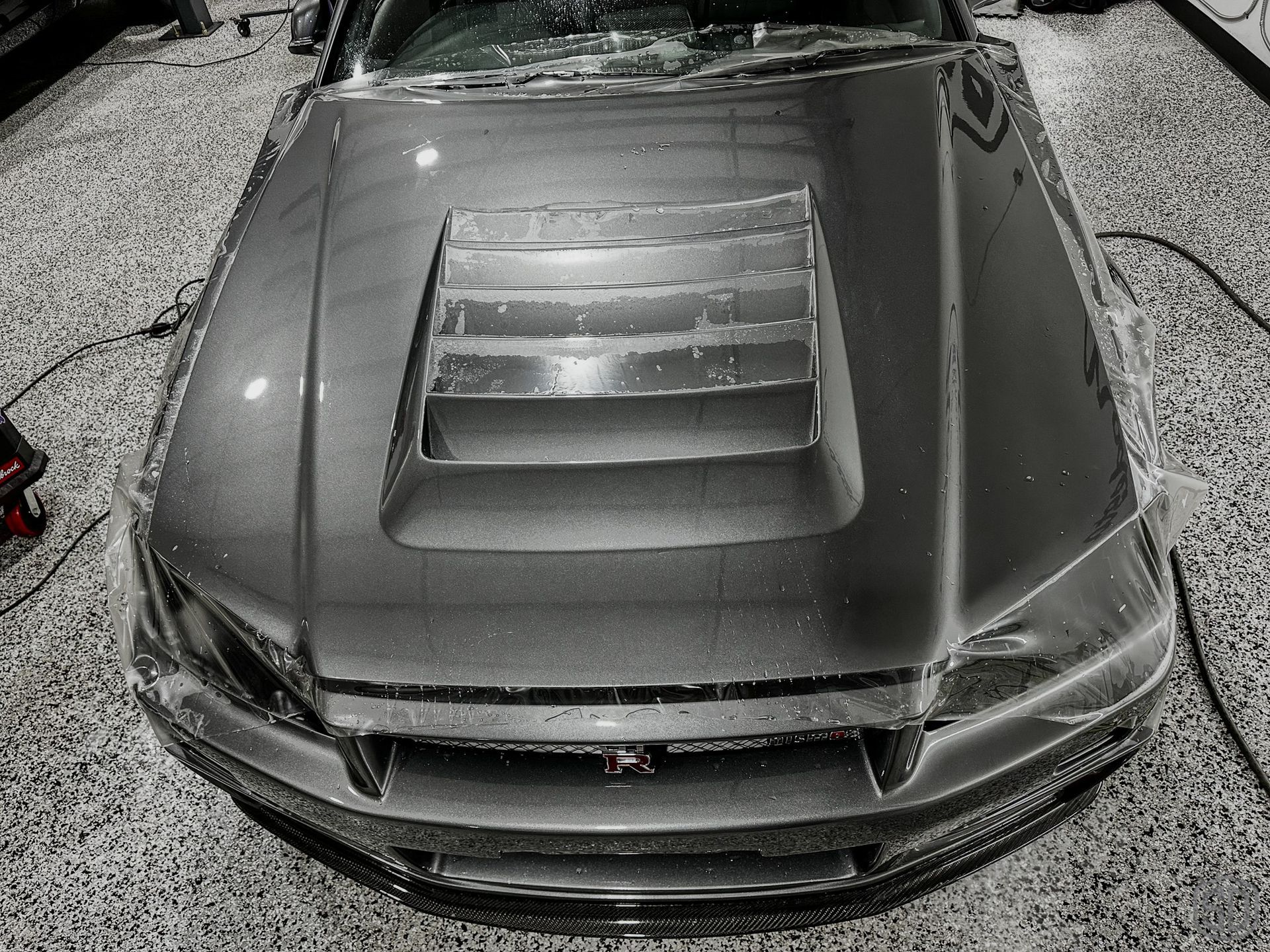 A black and white photo of a car parked in a garage.