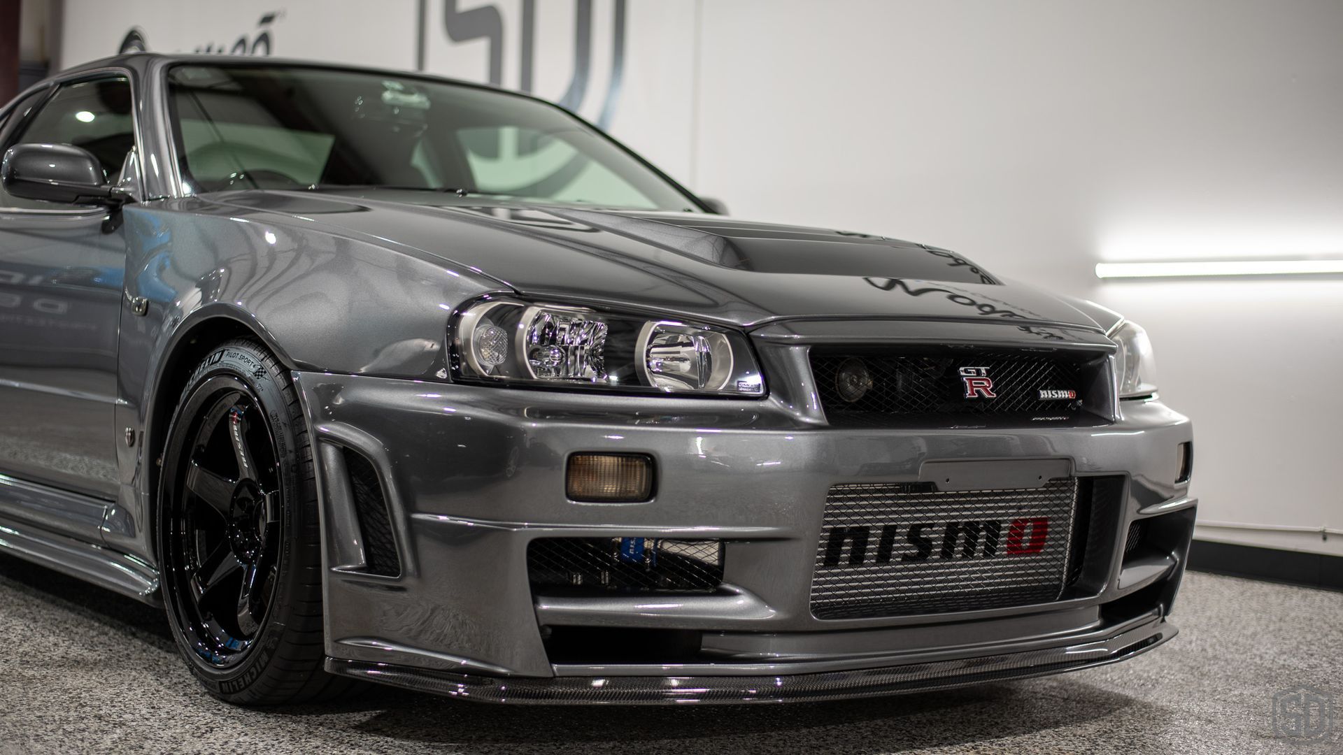 A nissan skyline r34 is parked in a garage.