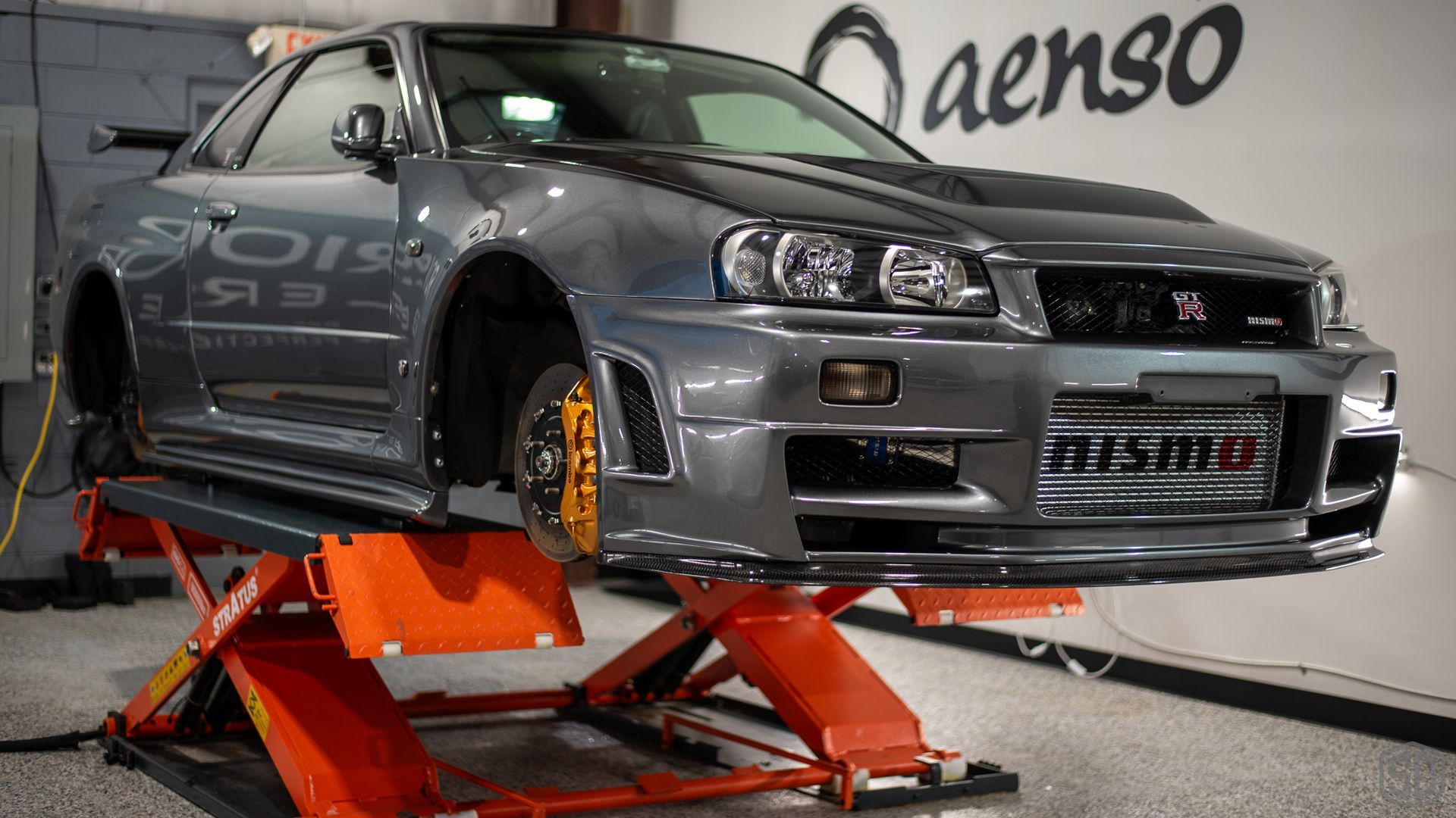 A car is sitting on a lift in a garage.