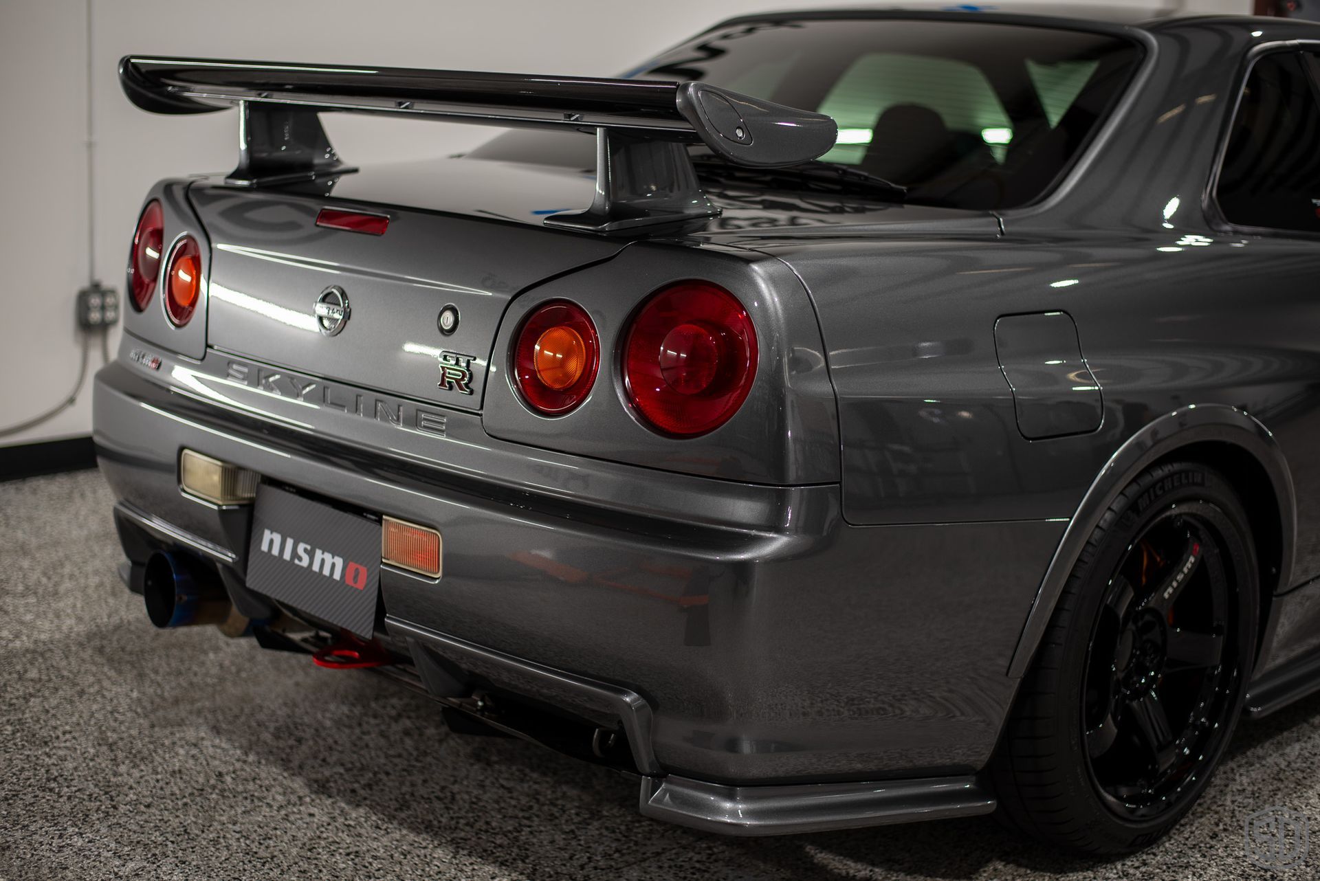 A nissan skyline r34 is parked in a garage.