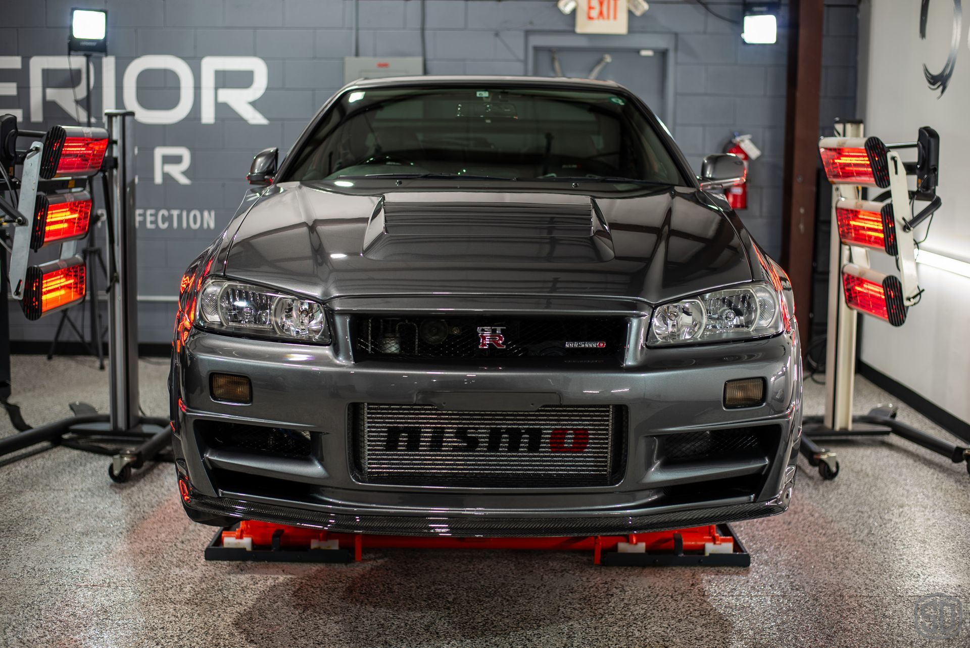 A car is sitting on a lift in a garage.