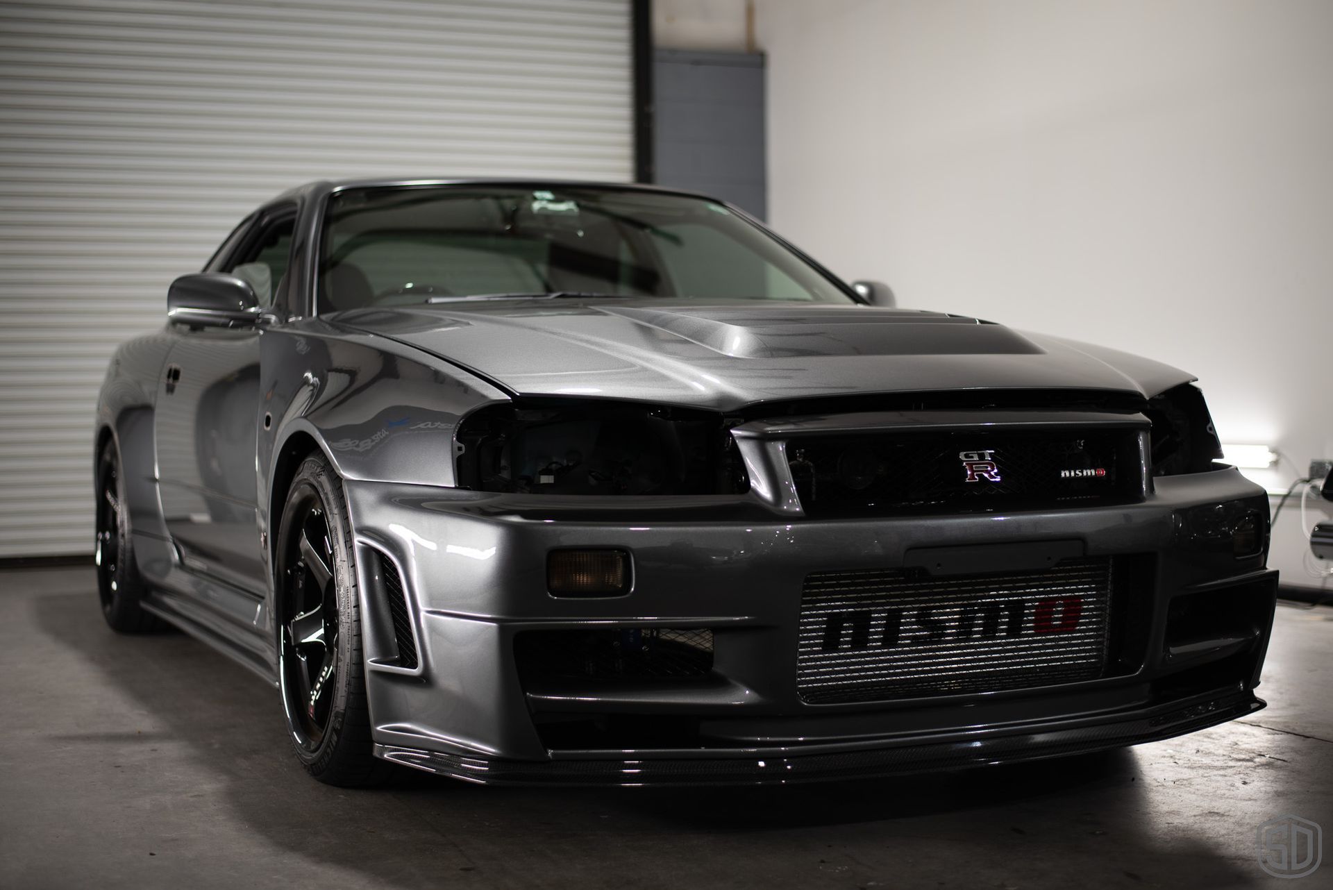 A nissan skyline gtr is parked in a garage.