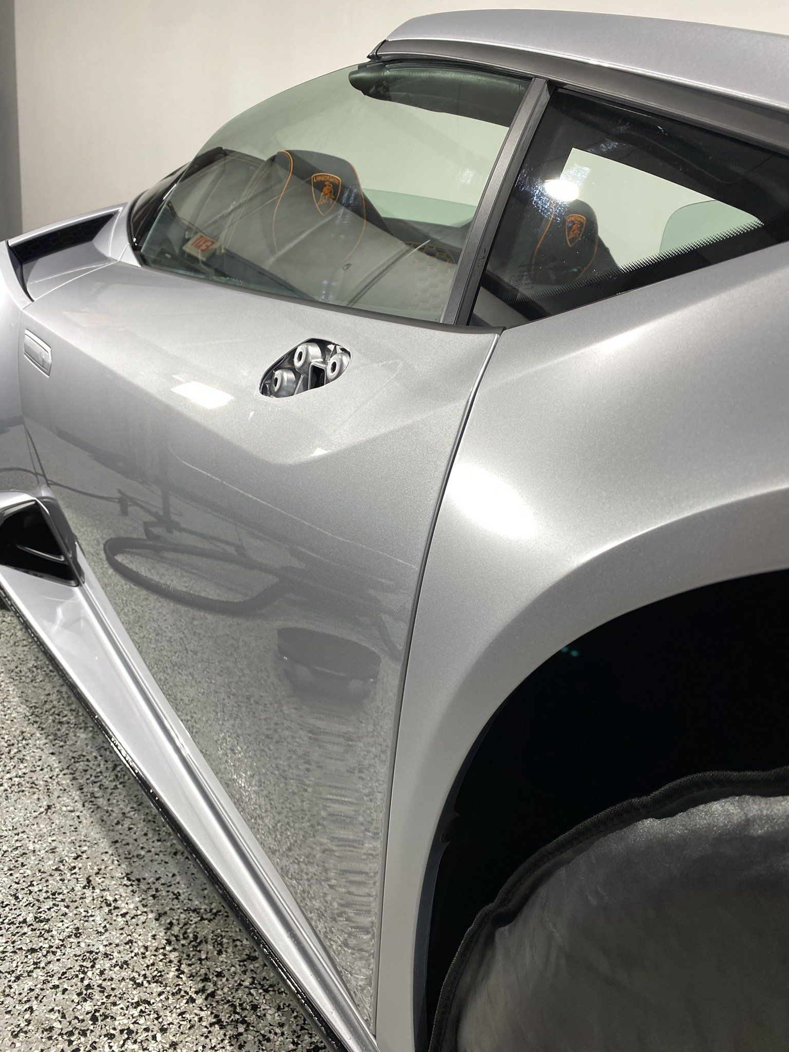 A silver sports car is parked in a garage.
