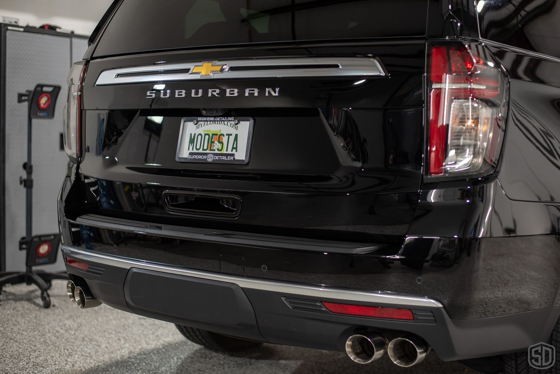 A black suv with a new york license plate is parked in a garage.