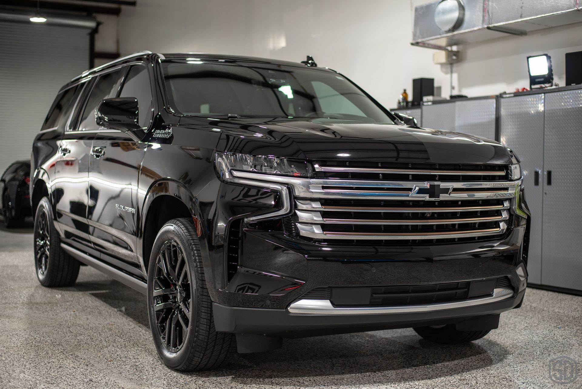 A black suv is parked in a garage.