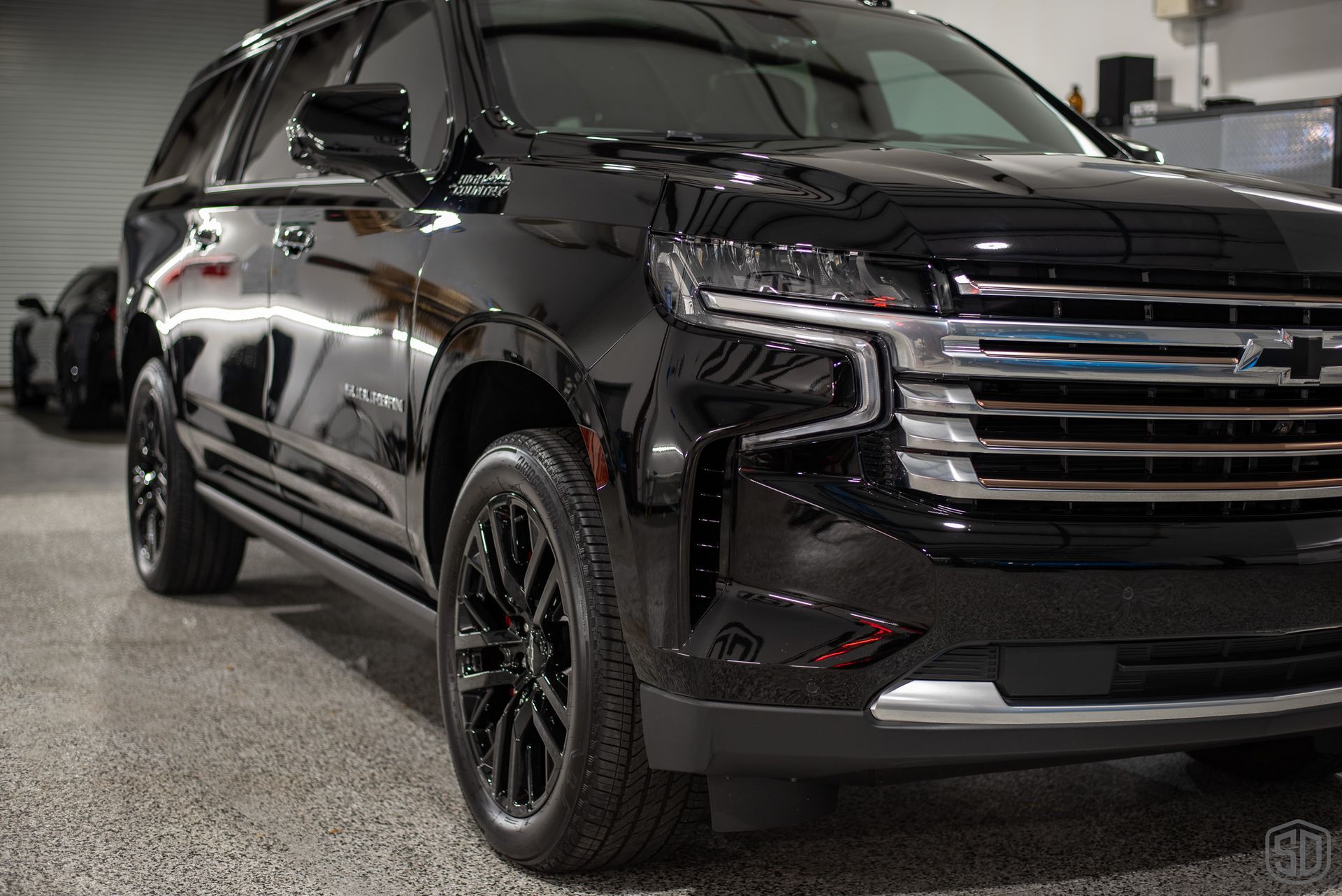 A black suv is parked in a garage.