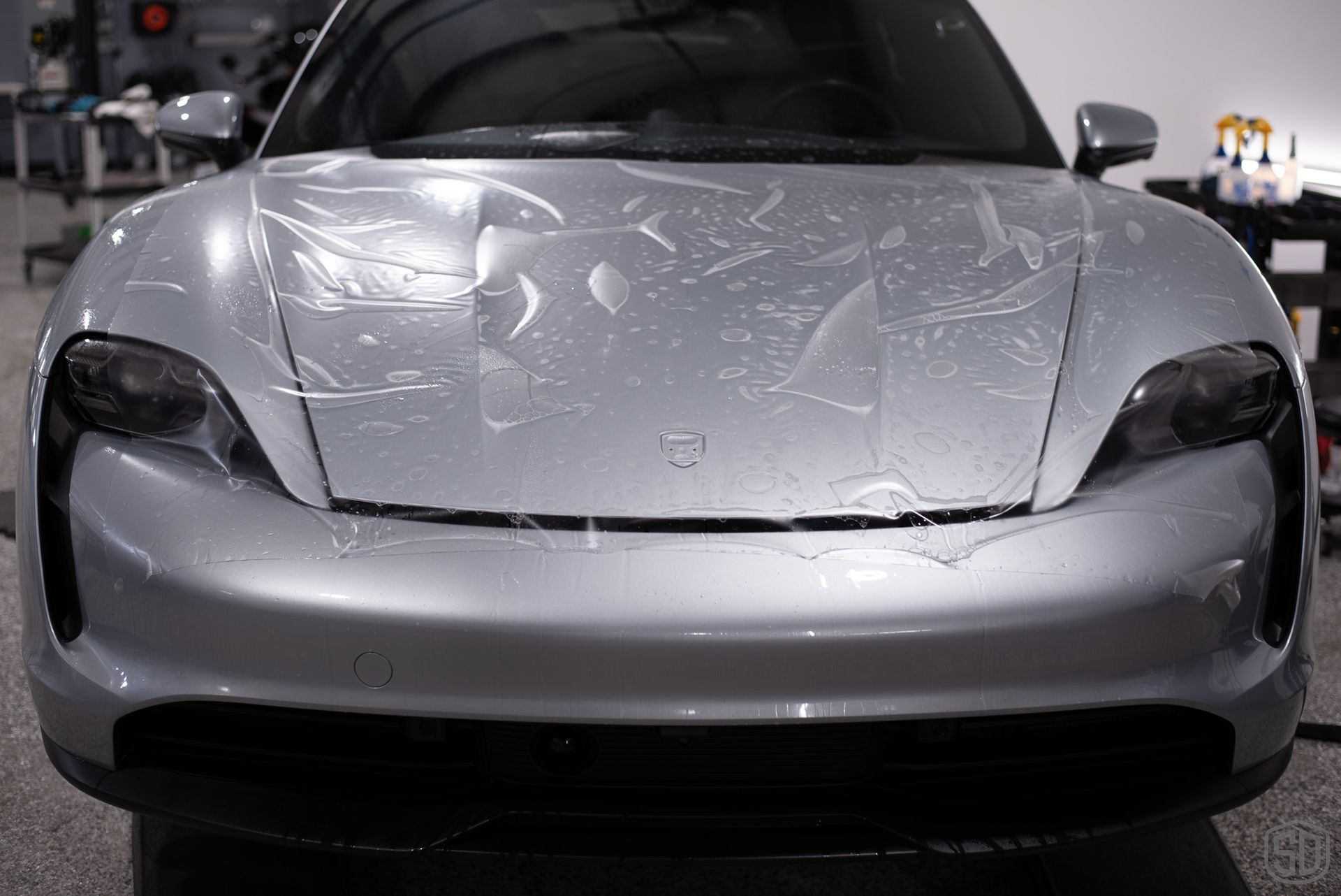 The front of a silver porsche taycan wrapped in PPF.