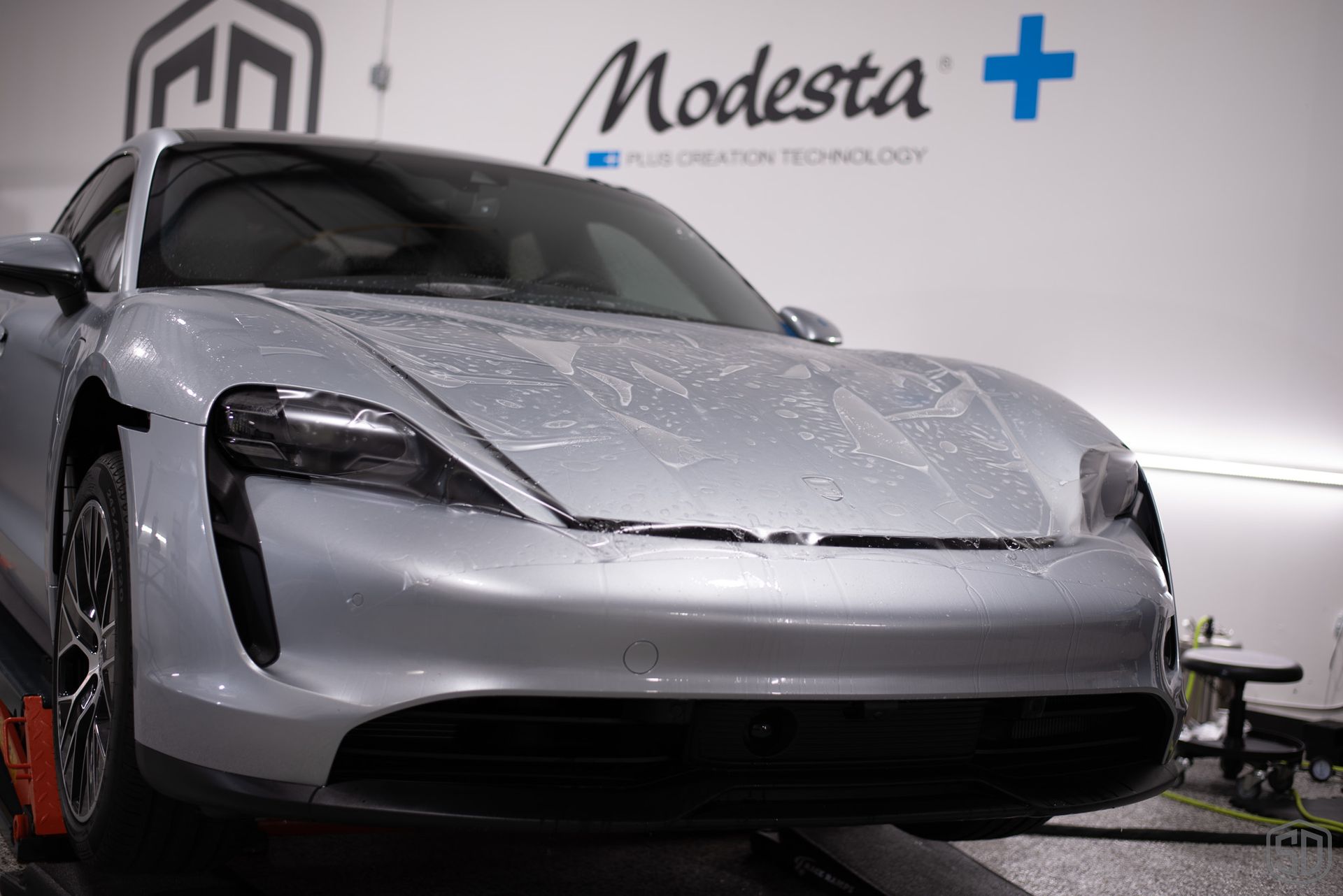 The front hood of a silver porsche taycan wrapped in PPF.