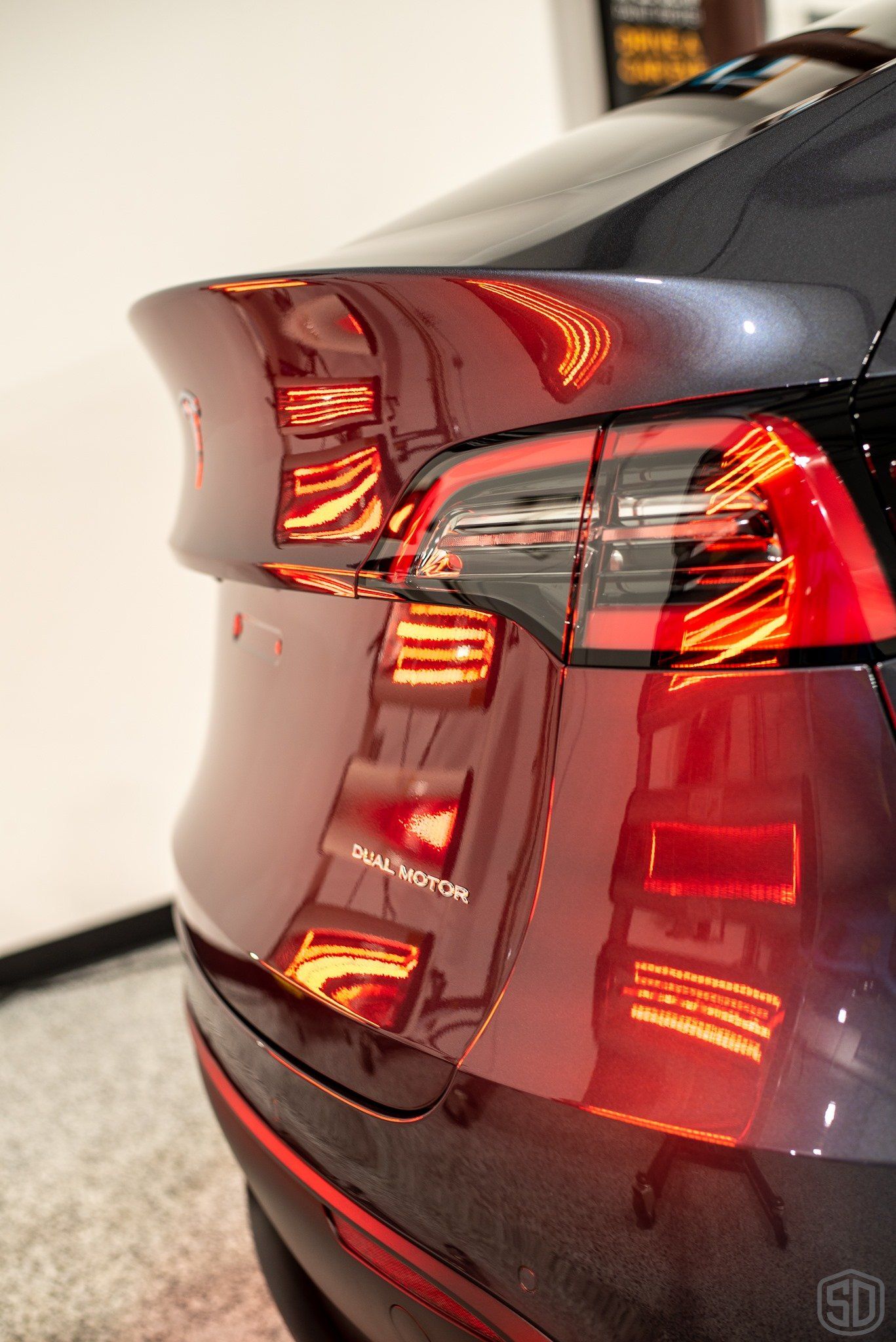 A close up of the back of a tesla model s parked in a garage.