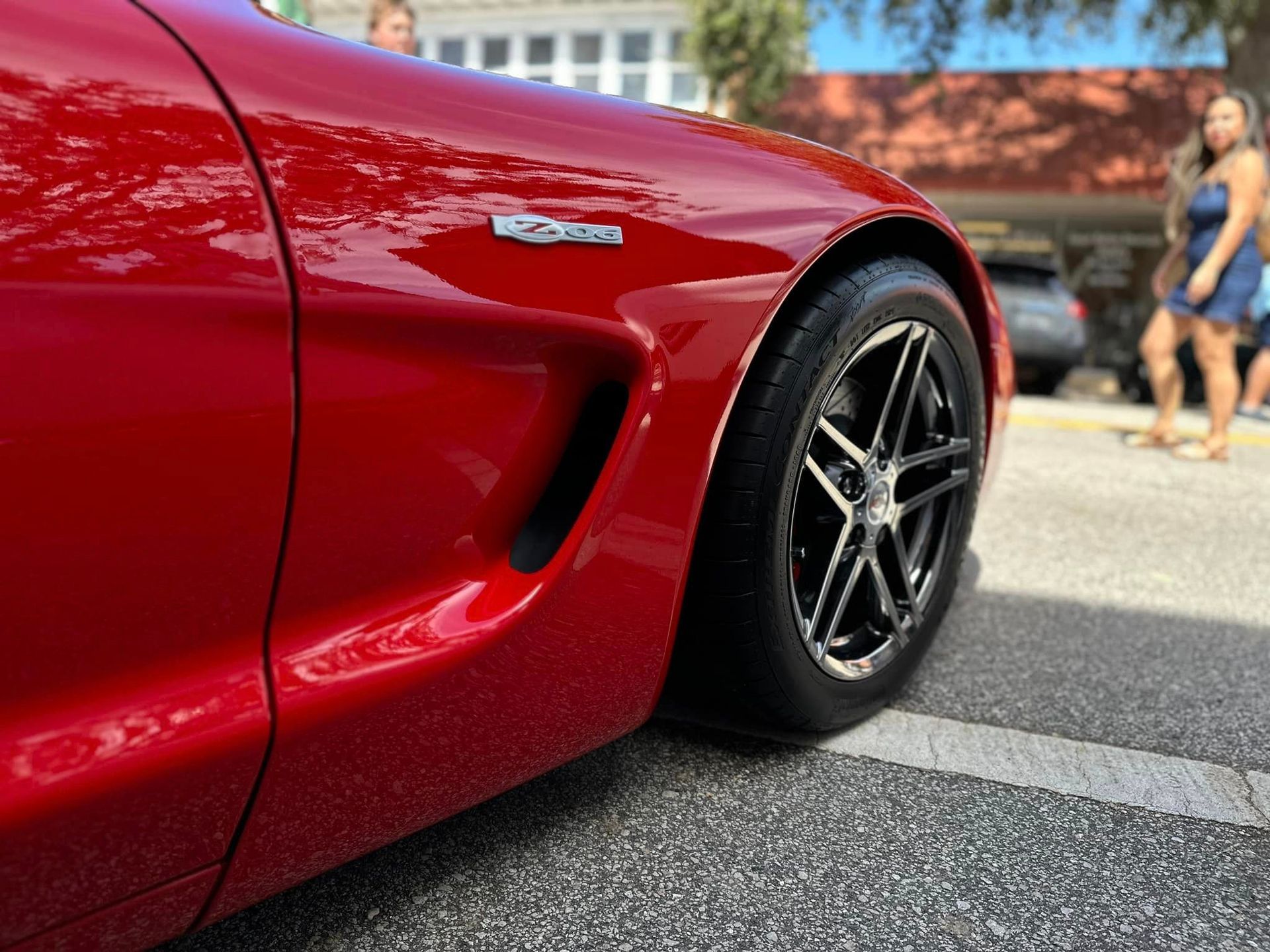 A red sports car is parked on the side of the road.