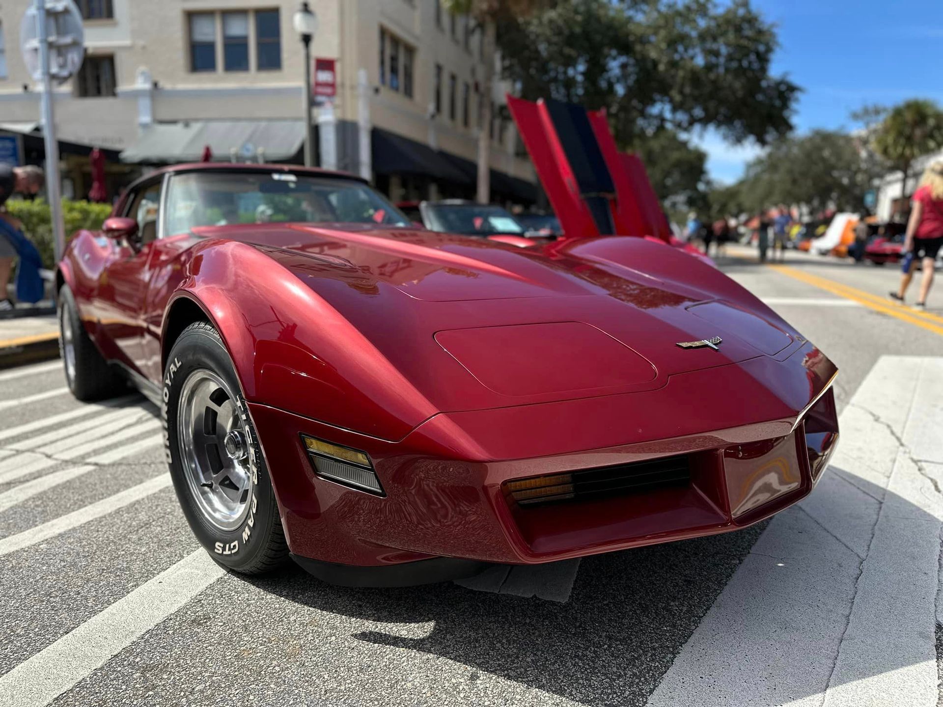 A red corvette is parked on the side of the road.