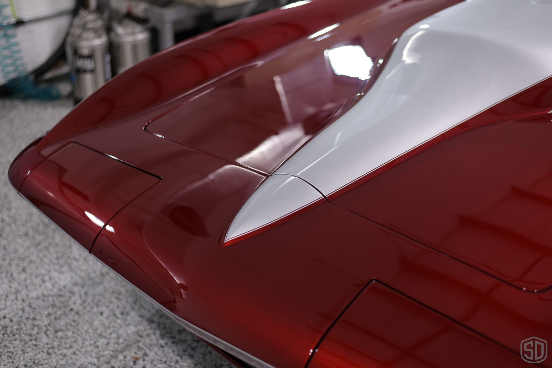 A red and white car is parked in a garage.