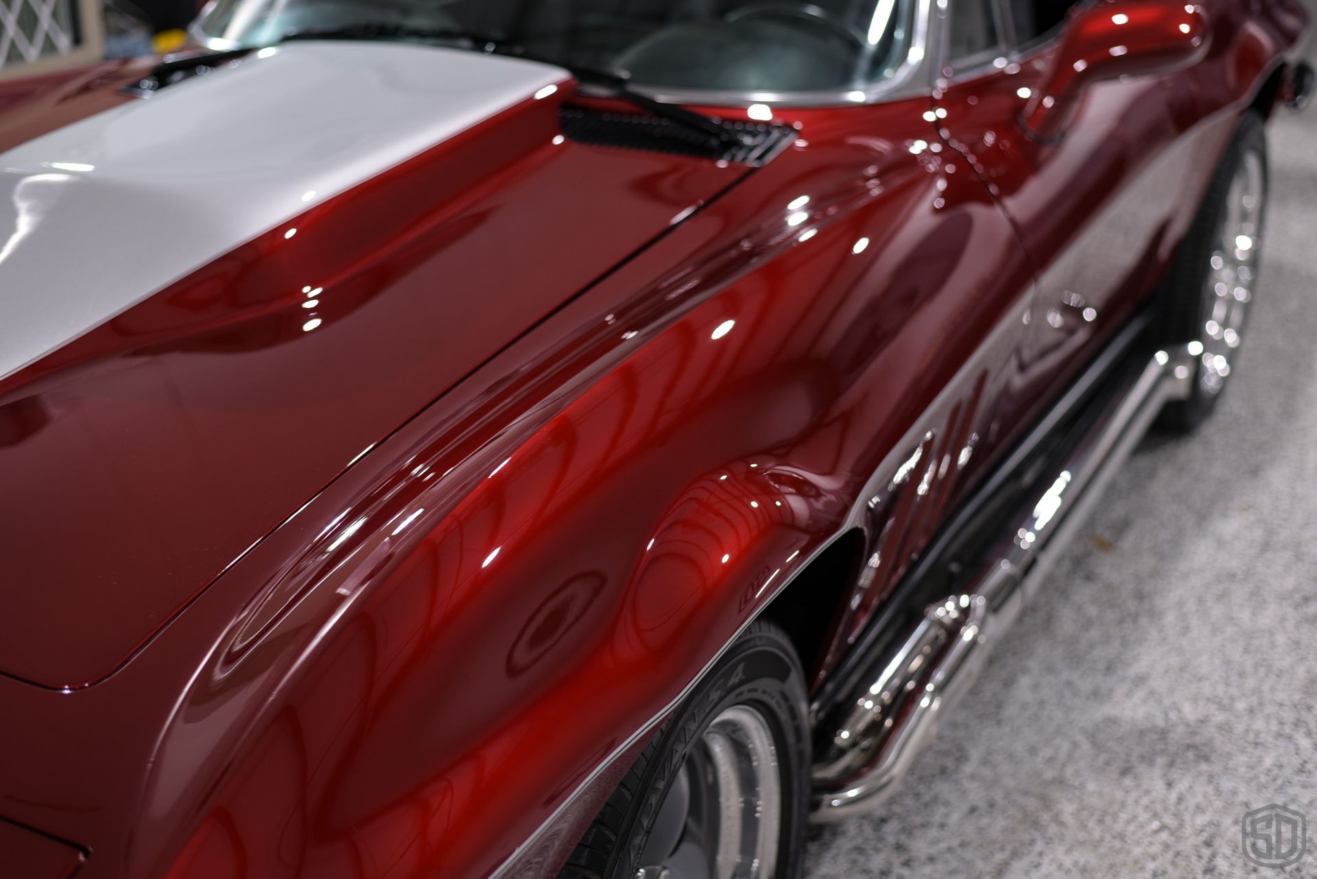 A red car with a white stripe on the hood