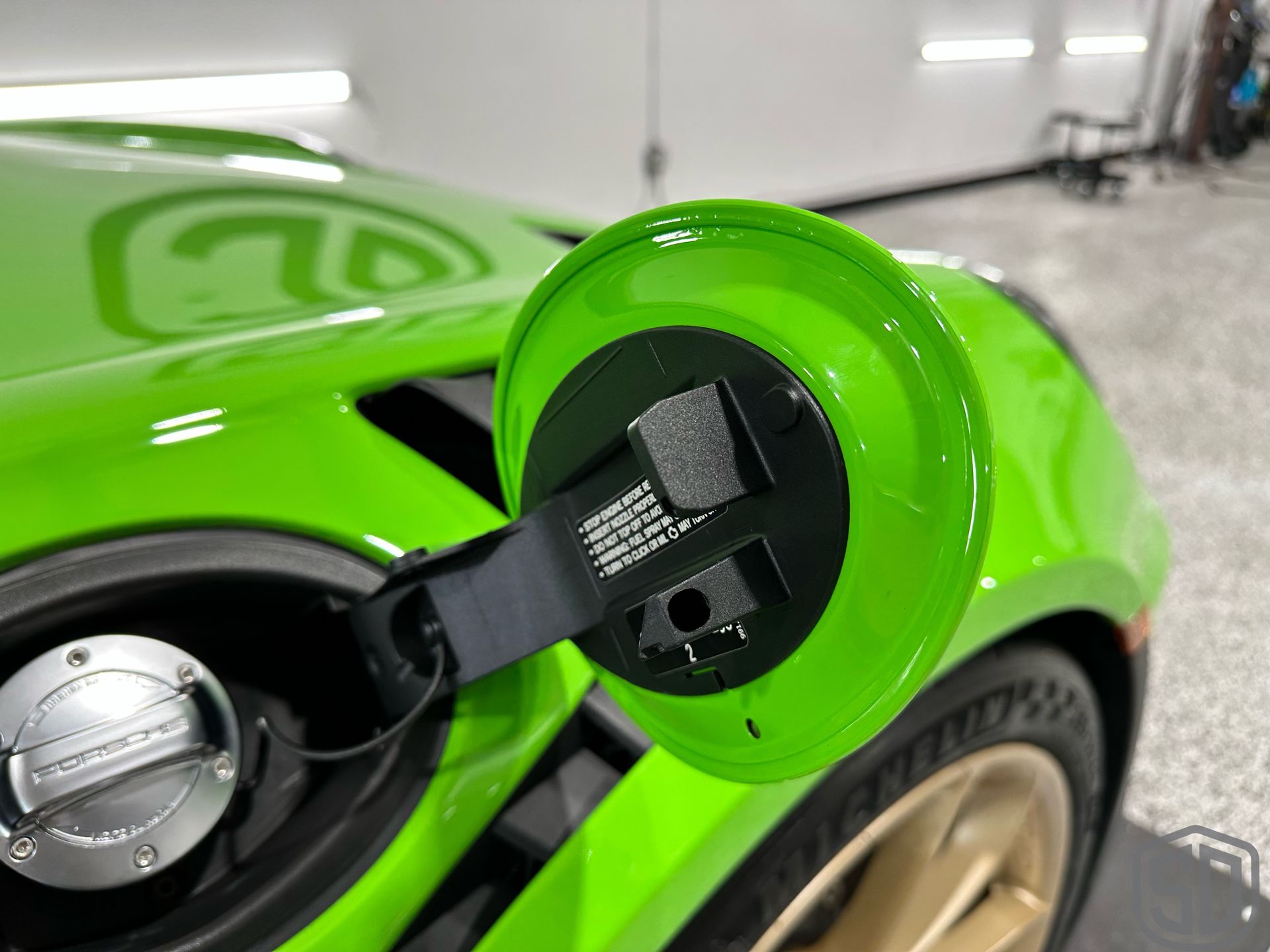 A close up of a green car with a fuel cap on it.