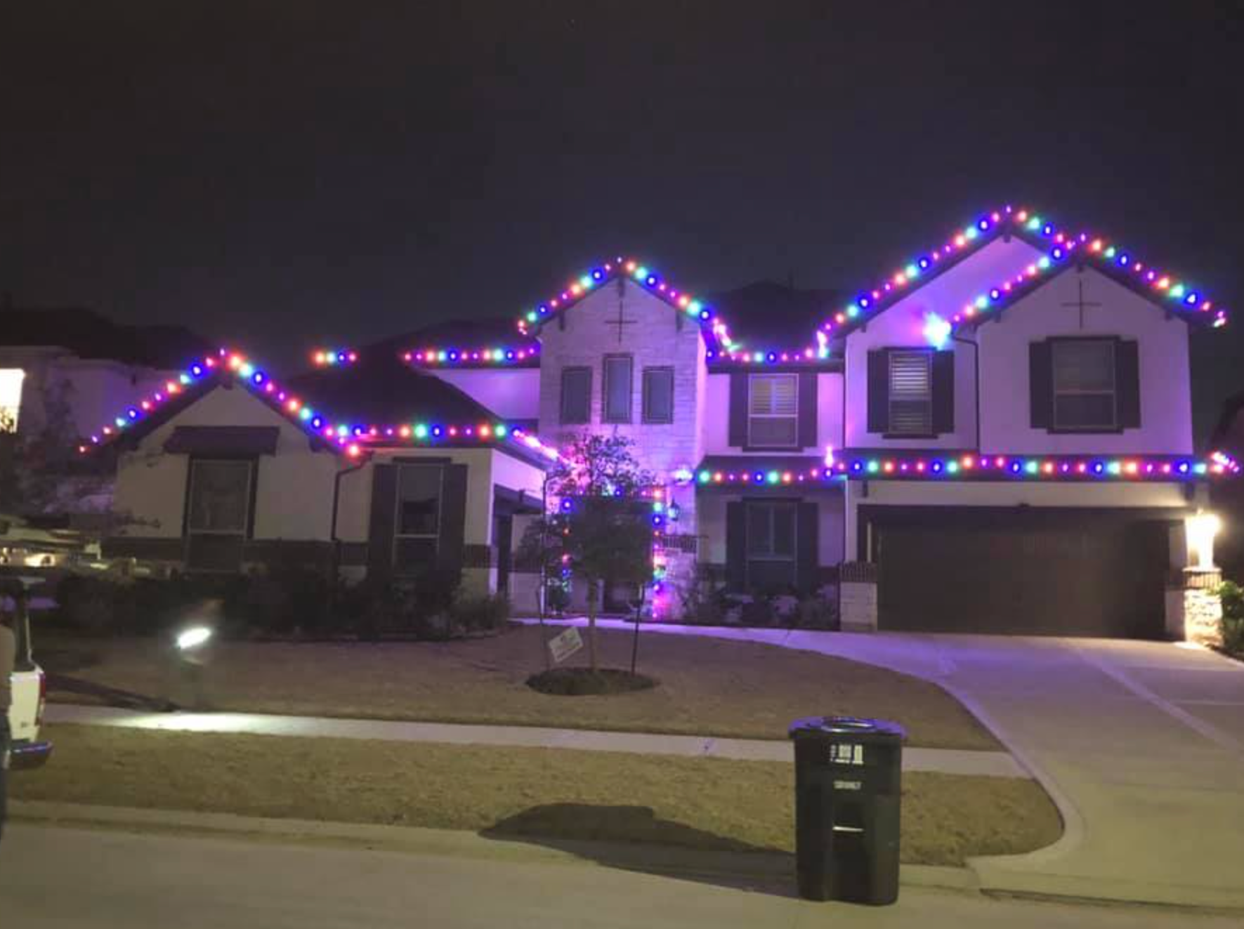 House decorated with colorful Christmas lights at night.