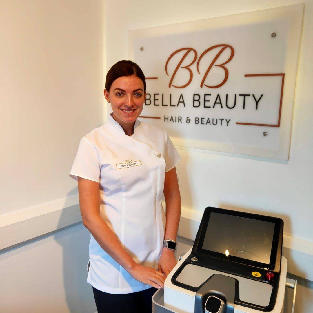 A woman stands in front of a sign that says bella beauty