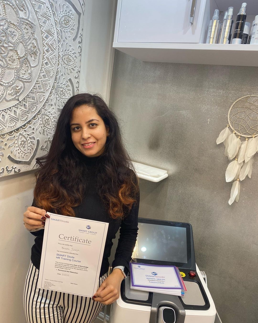 A woman is holding a certificate in front of a machine.