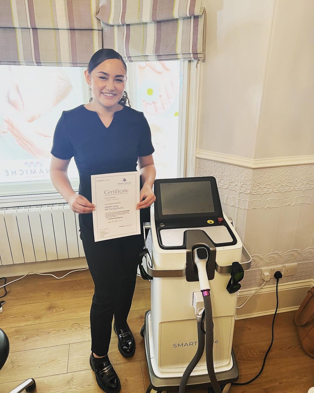 A woman is standing next to a machine holding a piece of paper.