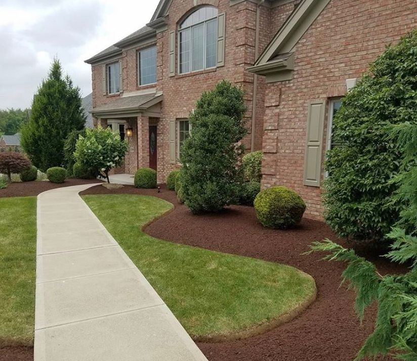 Brick house with a landscaped front yard and a concrete walkway.