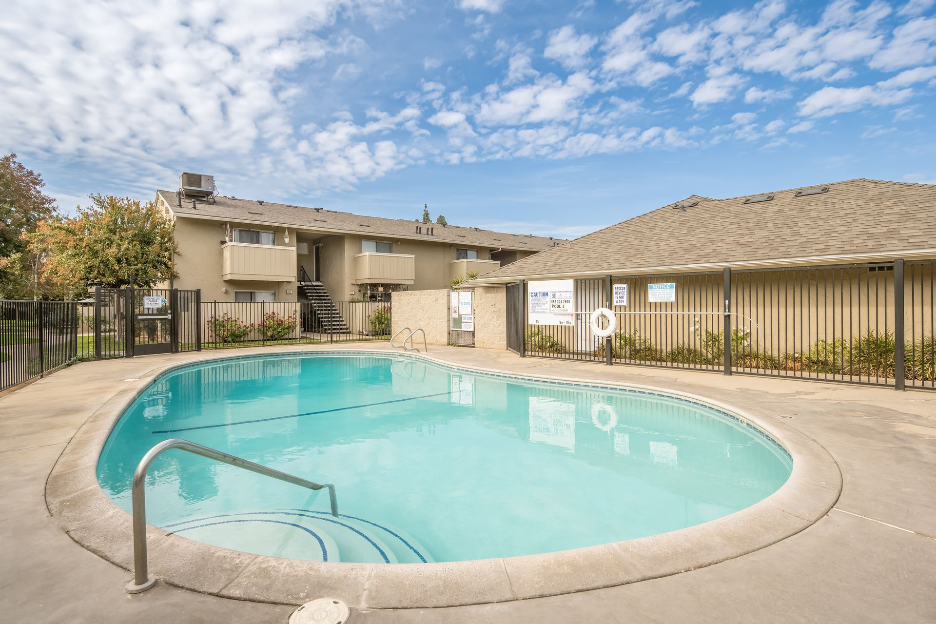 Swimming pool in front of apartment buildings on a sunny day.