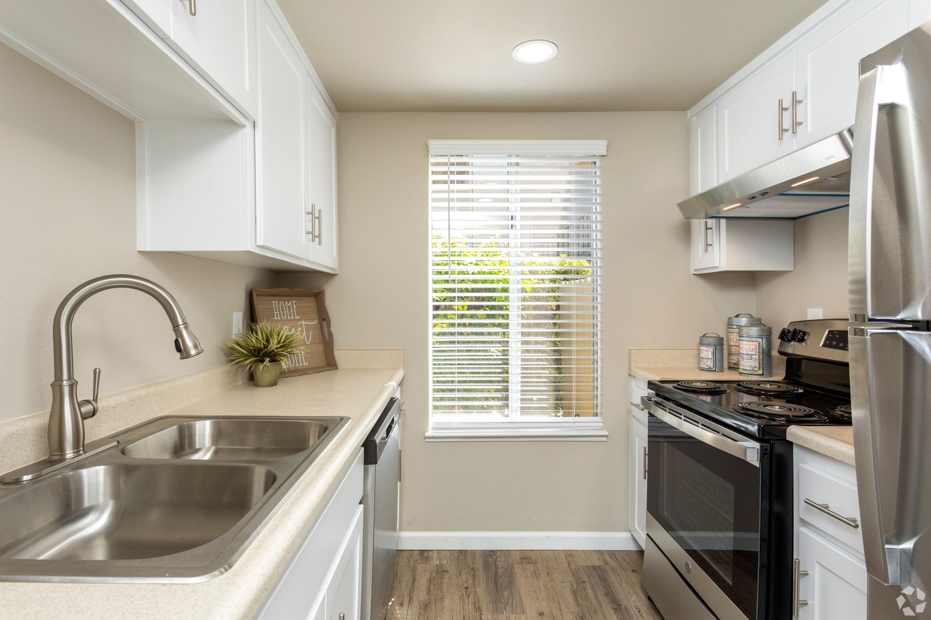 Living room with vaulted white ceiling, brick fireplace, and beige sofa.