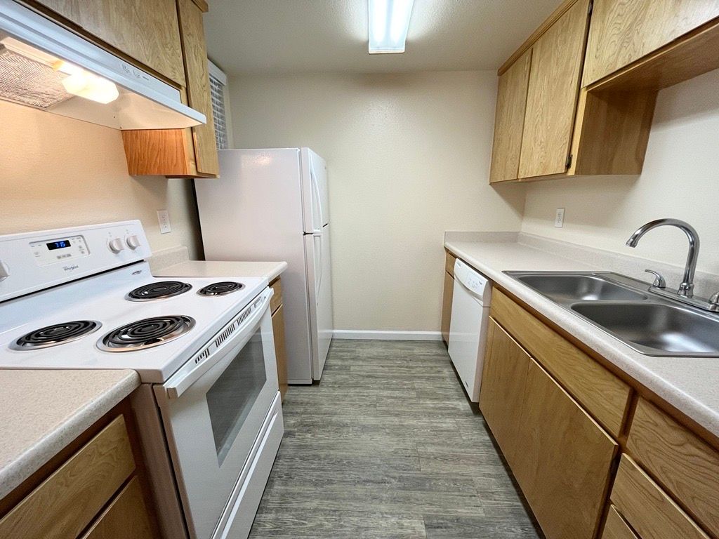 Kitchen with white appliances and light-colored cabinets.