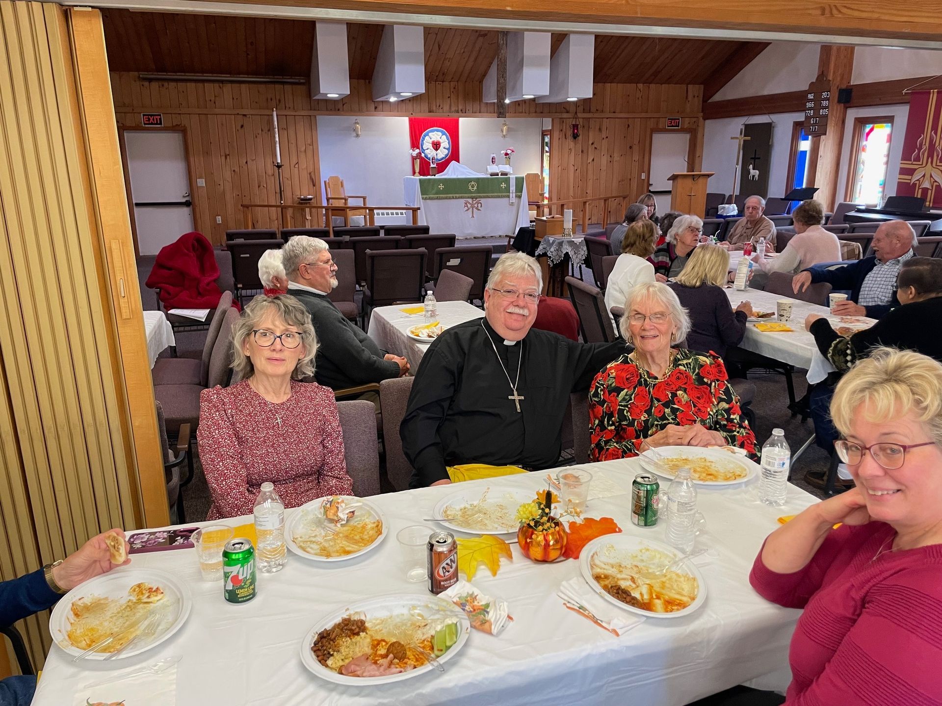 A group of people are sitting at a table with plates of food.