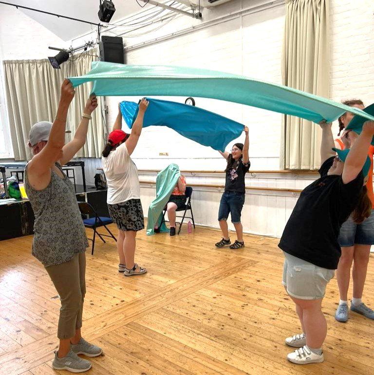 At Ashcroft Arts Centre, Fareham, pairs of FNC members use coloured sheets raising them above their heads - arms stretched and pull down.