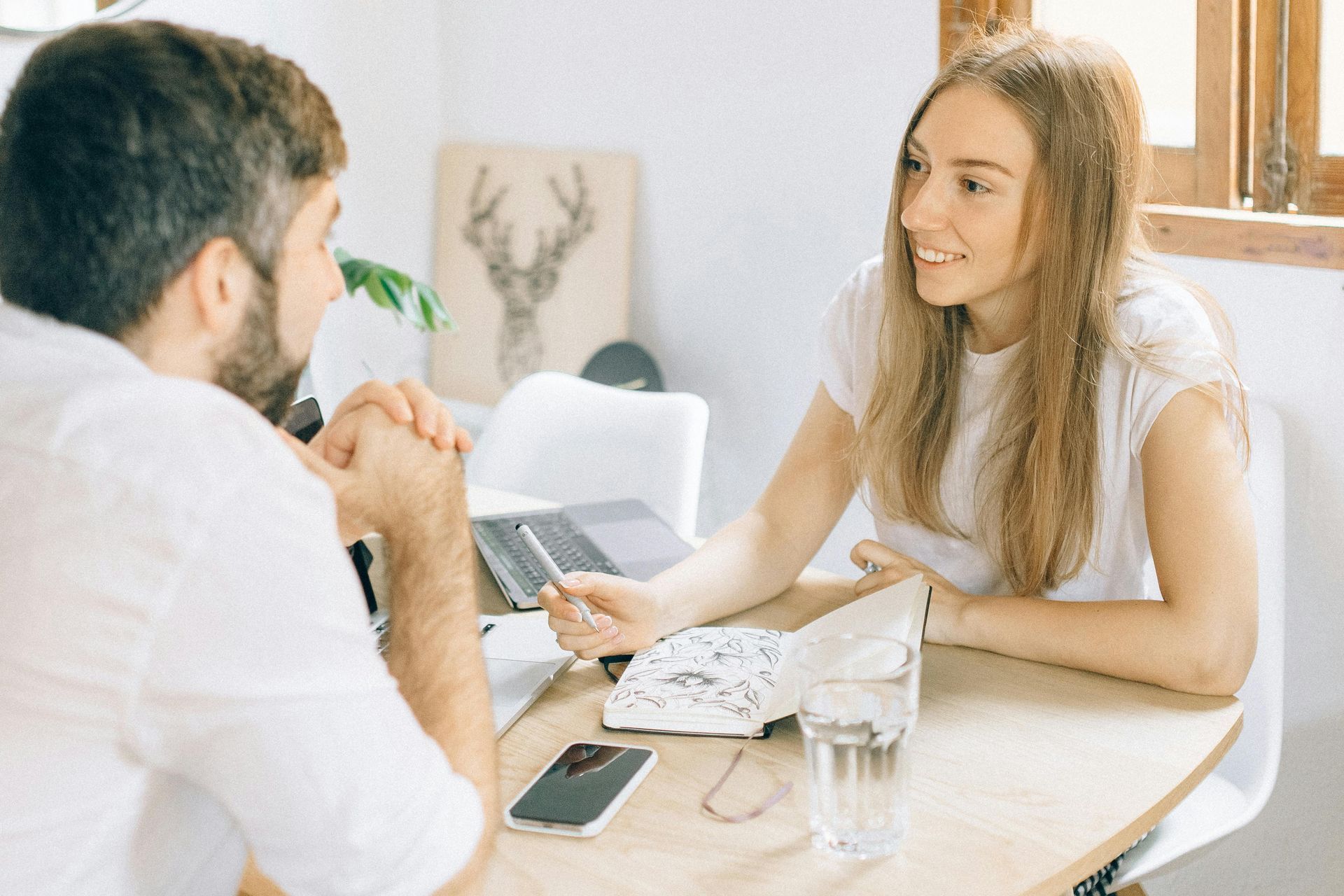 Property Manager Smiling at Tenant during Discussion at a Table