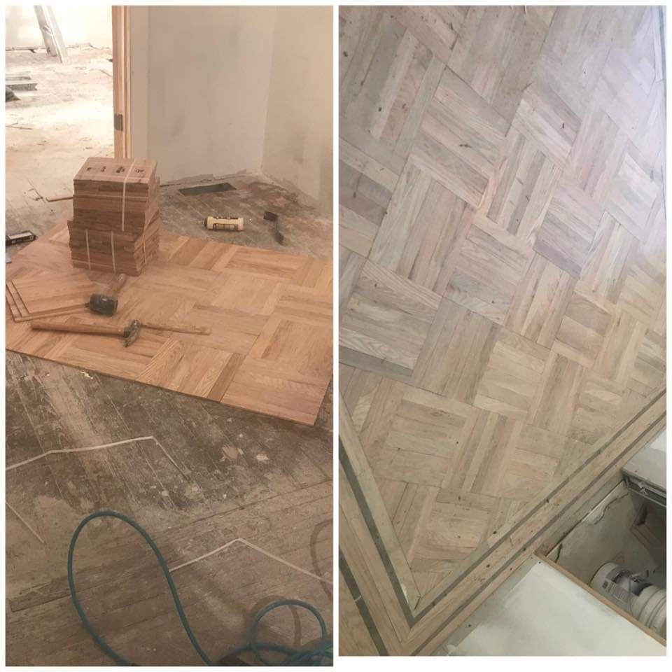 Parquet flooring installation in progress; wood tiles laid on concrete; close-up of finished floor detail.