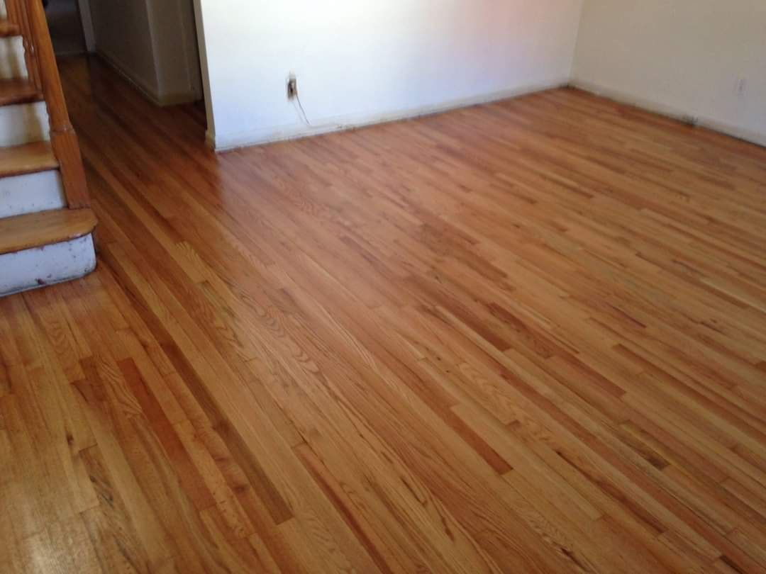 Hardwood floor in a room, with stairs visible on the left.