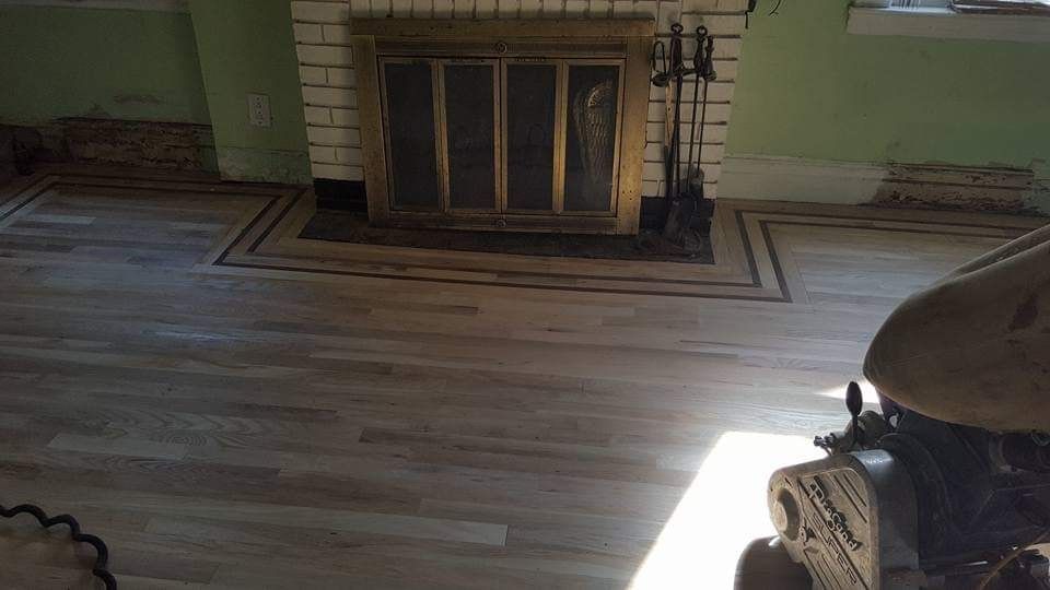 Fireplace with gold doors and hardwood floors.