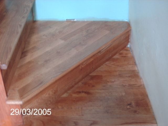 Wooden stairs with a turn, viewed from above, with date 