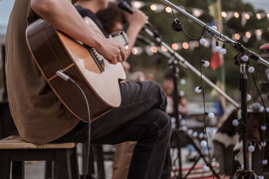 A man is playing an acoustic guitar and singing into a microphone.