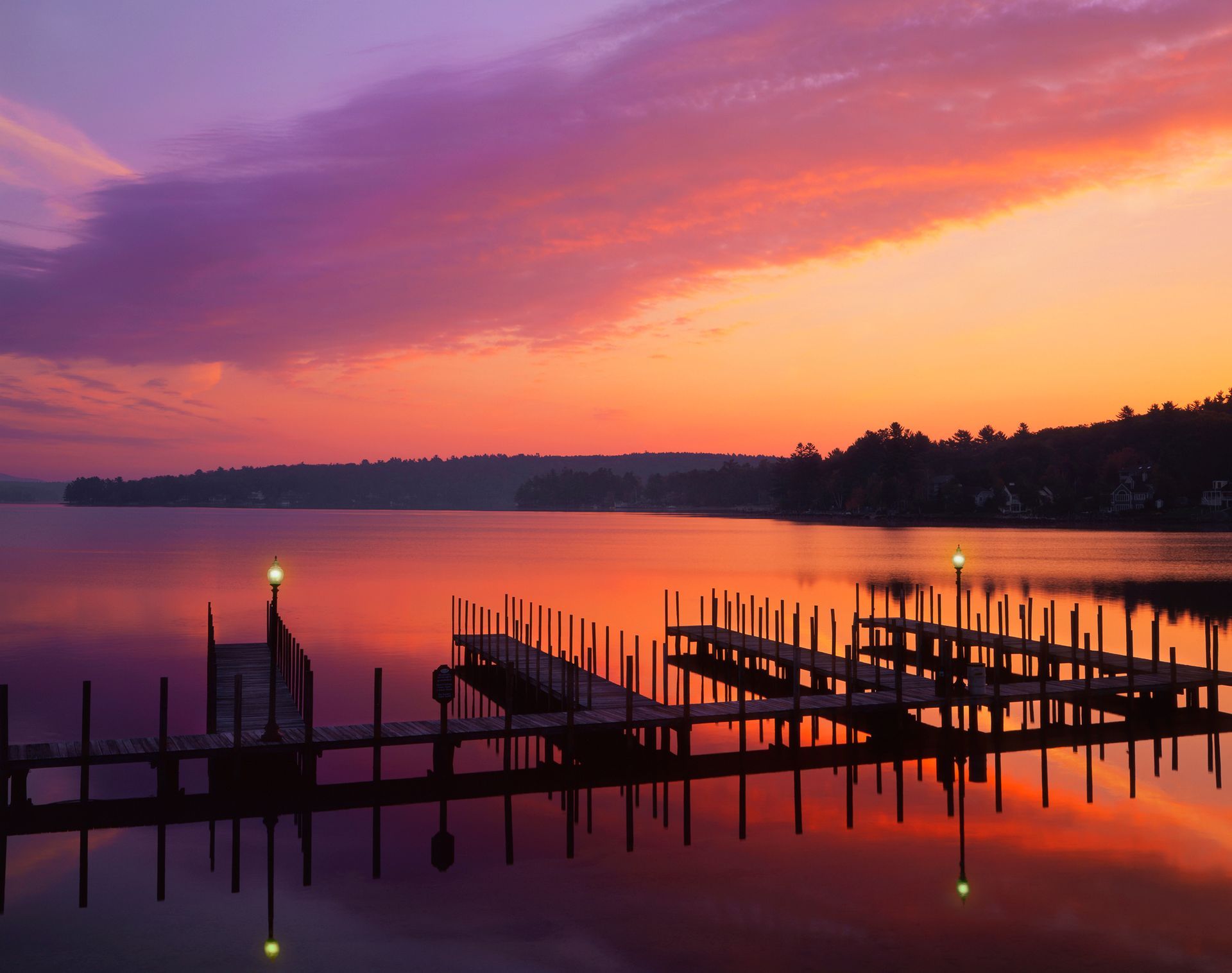 A sunset over a lake with a dock in the foreground