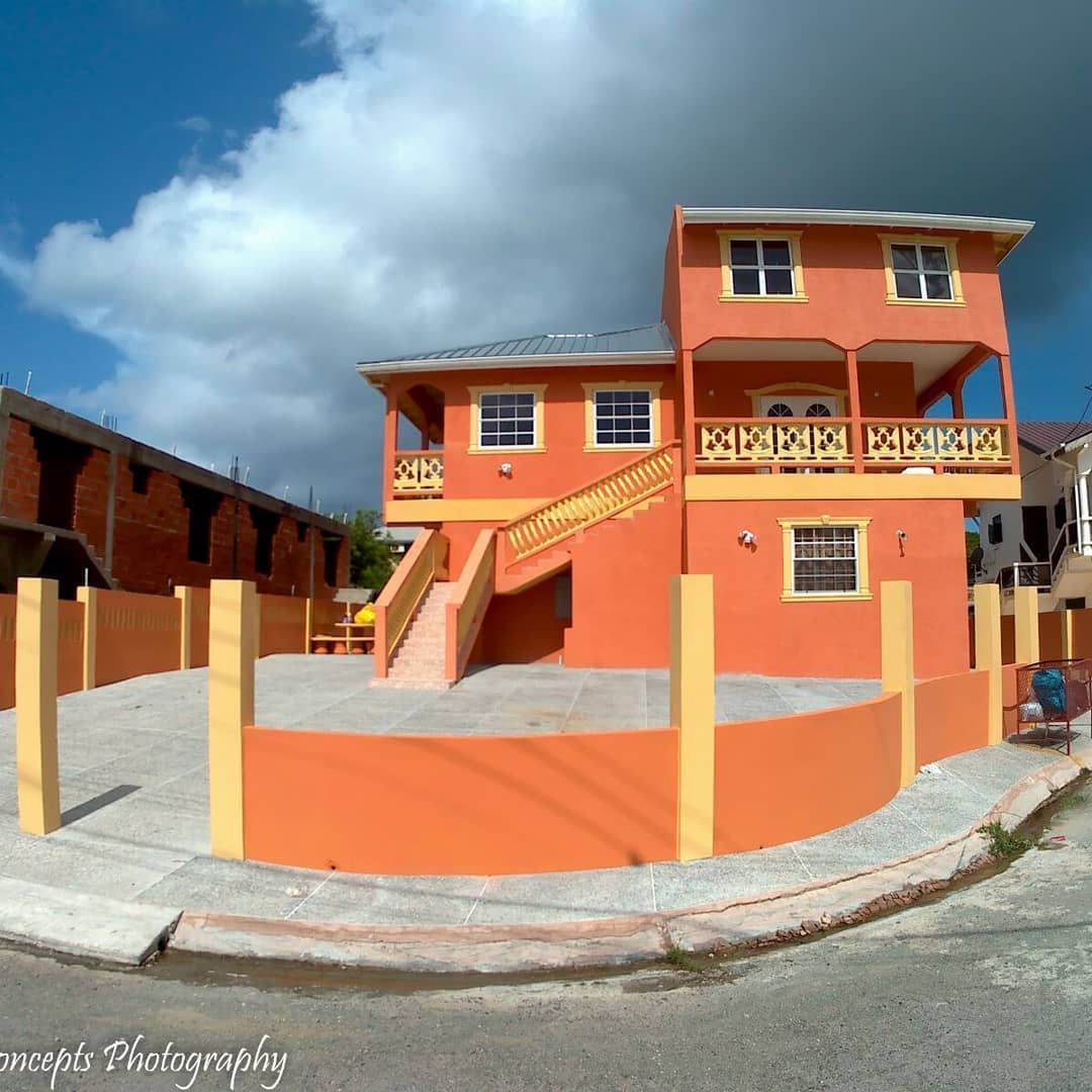 A large orange house with a balcony and stairs
